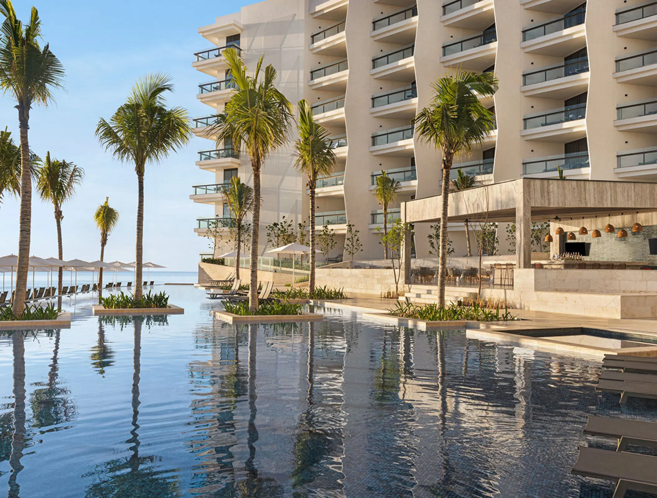 Hilton Cancun infinity pool and palm trees beside the guest room building, Cancun