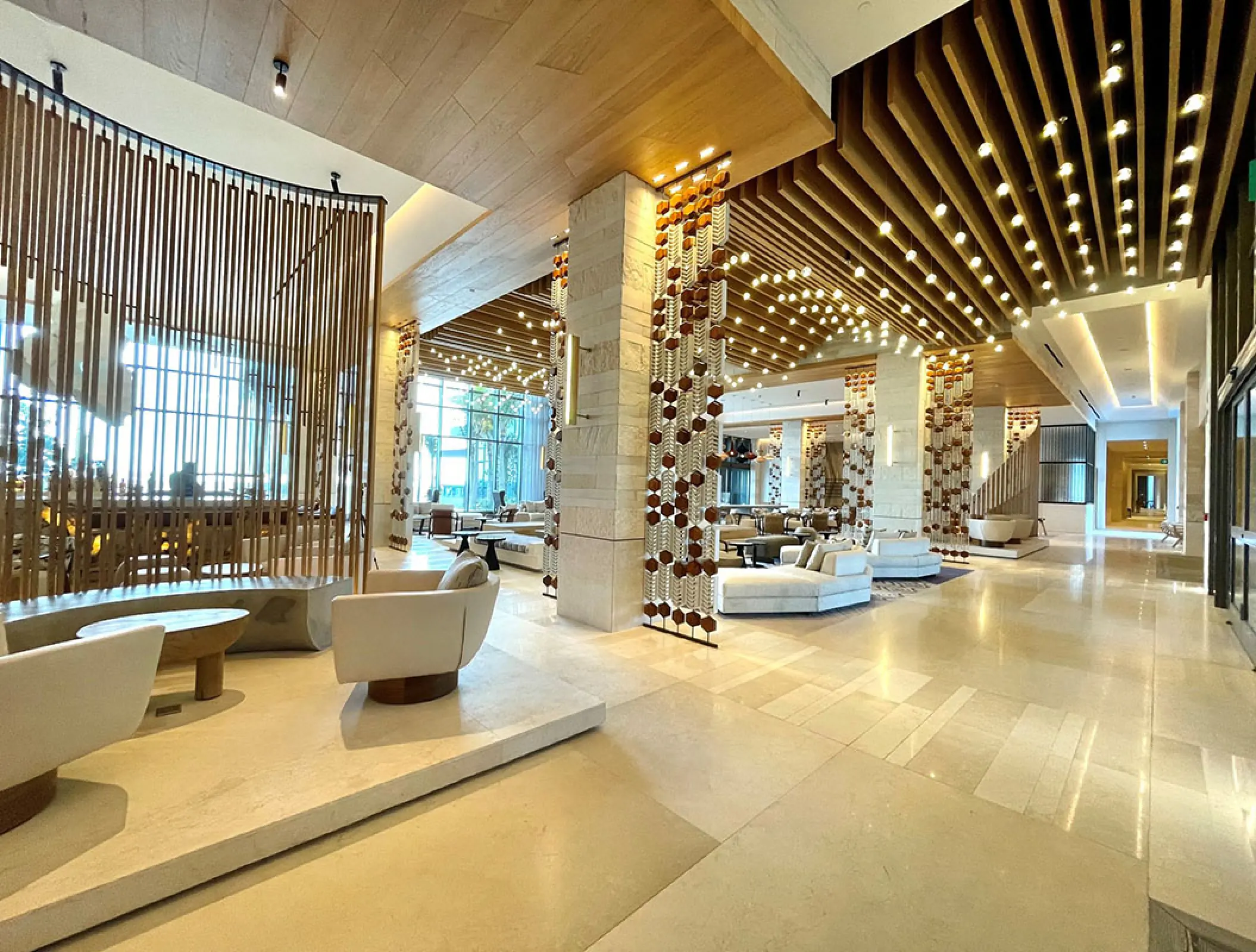 Modern open-concept lobby with wood accents and white seating at Hilton Cancun, Cancun