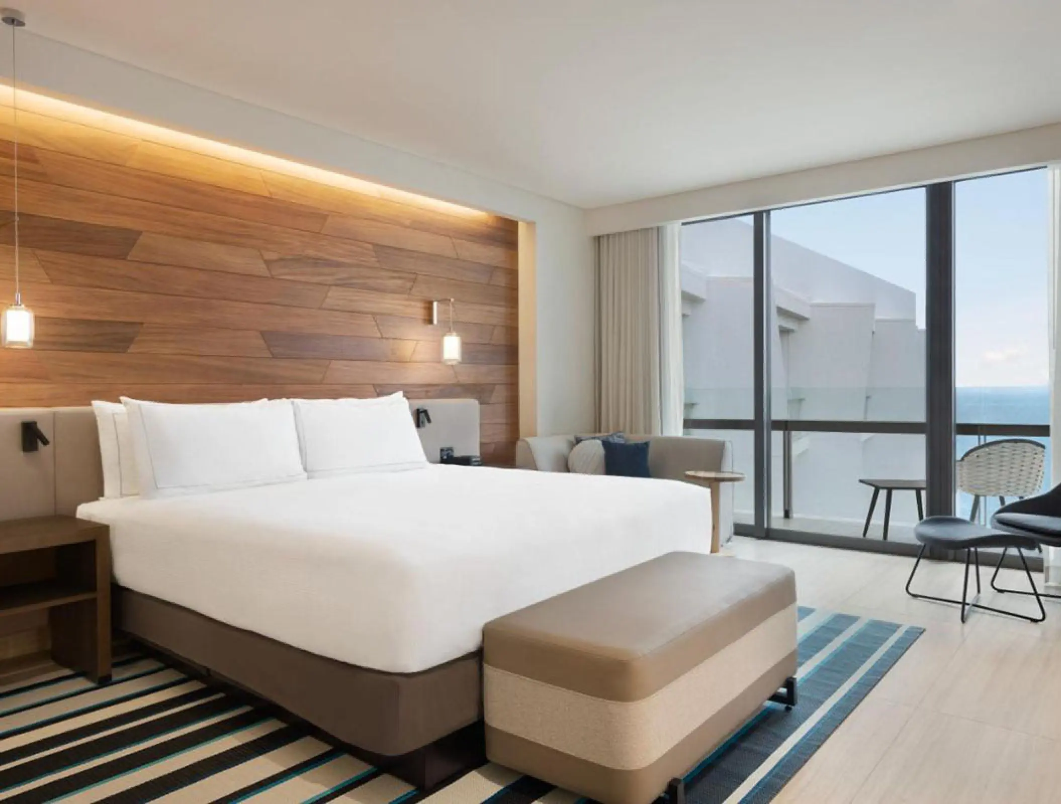 Modern ocean view guest room with wood paneling at Hilton Cancun