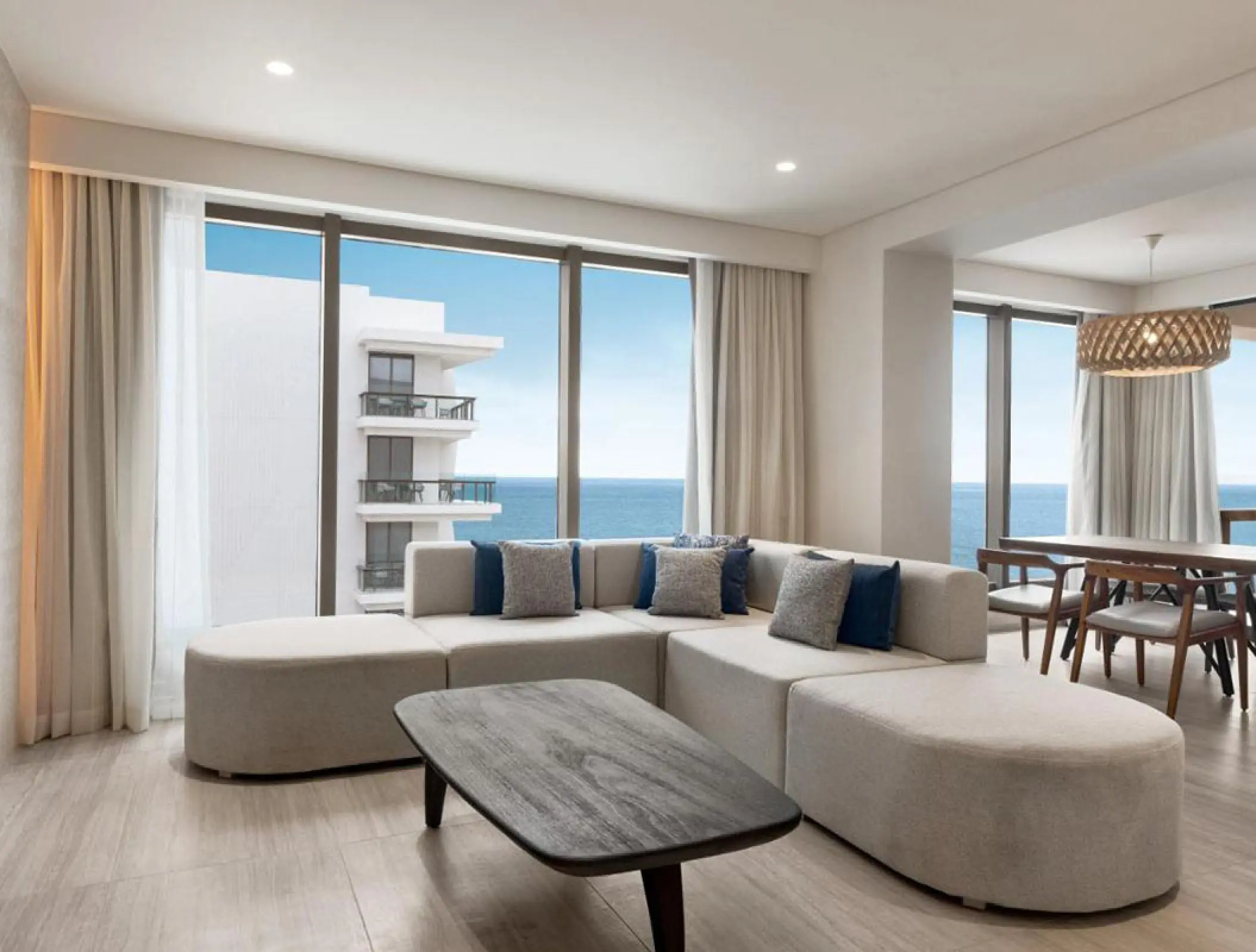 Ocean view suite with a large sectional sofa and floor-to-ceiling windows at Hilton Cancun