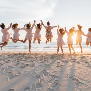 Bride and bridesmaids jumping on the beach at Hilton Cancun