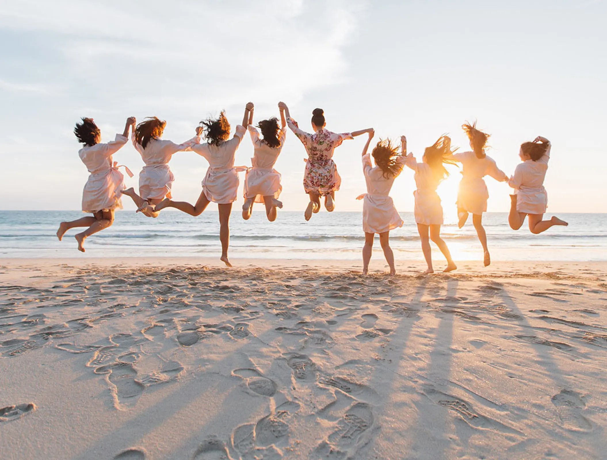 Bride and bridesmaids jumping on the beach at Hilton Cancun