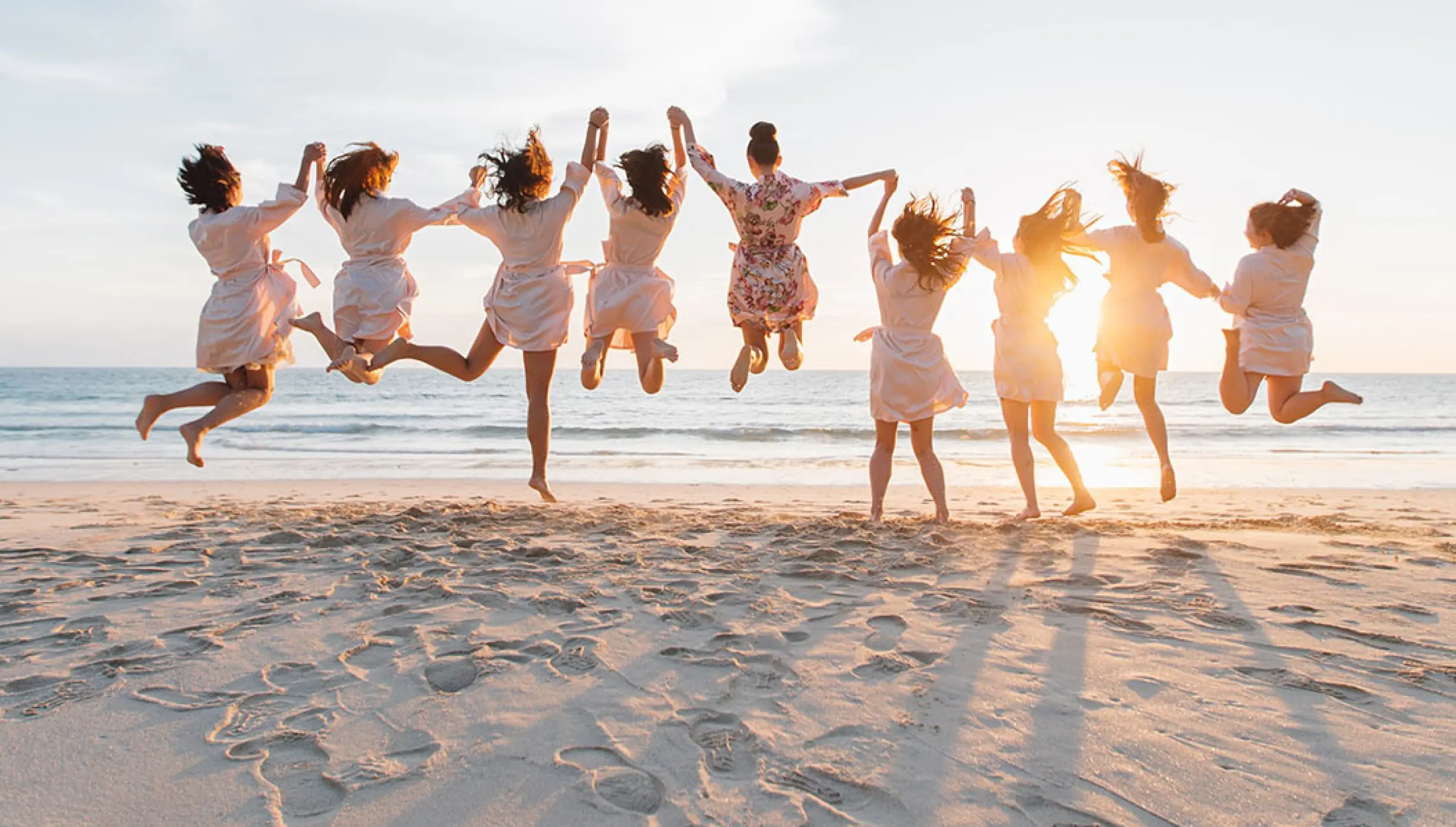 Bride and bridesmaids jumping on the beach at Hilton Cancun