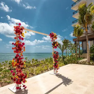 Floral wedding ceremony arch on an oceanfront terrace at Hilton Cancun, Cancun