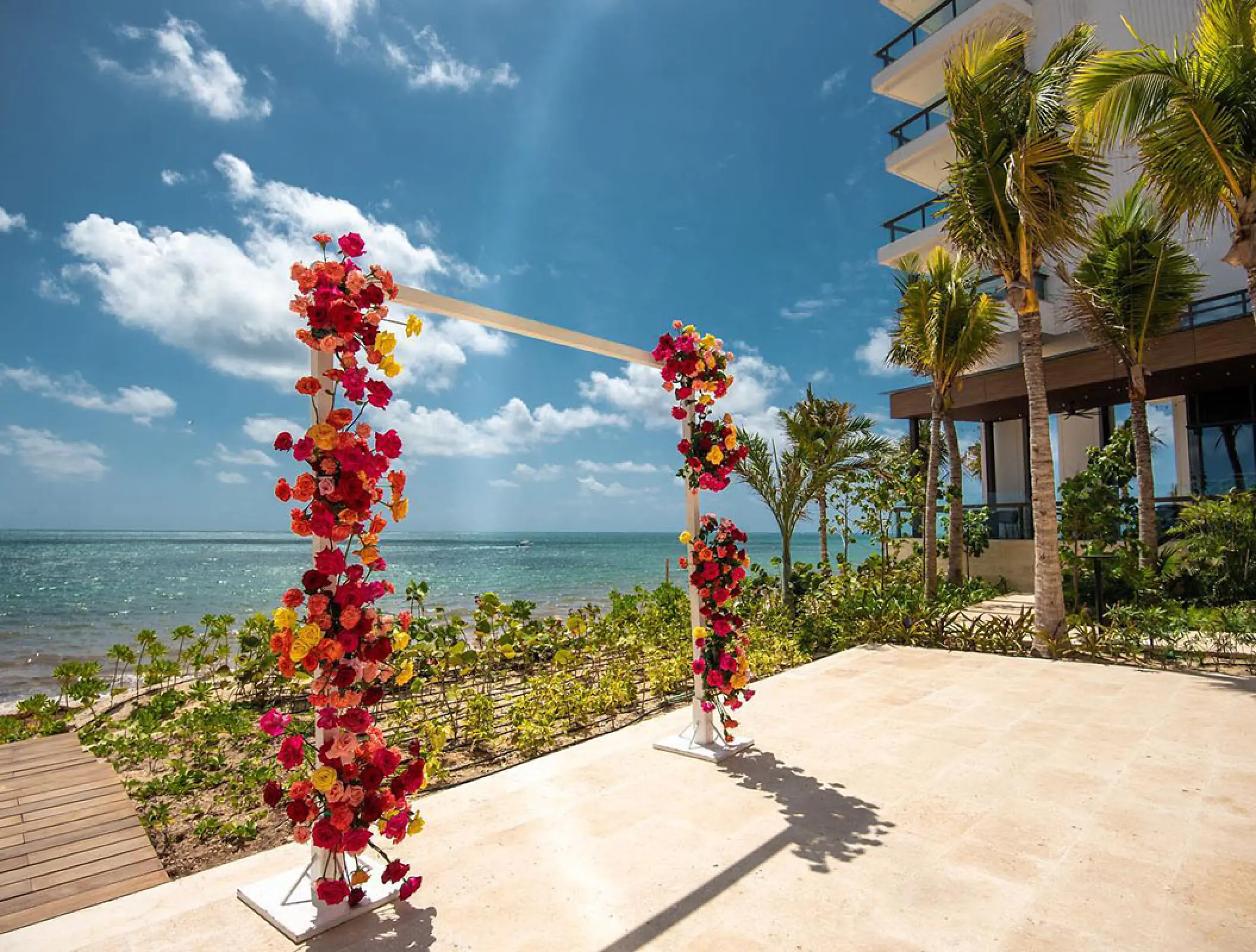 Floral wedding ceremony arch on an oceanfront terrace at Hilton Cancun, Cancun