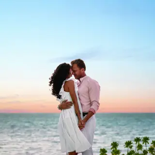 Couple embracing by the ocean at sunset at Hilton Cancun