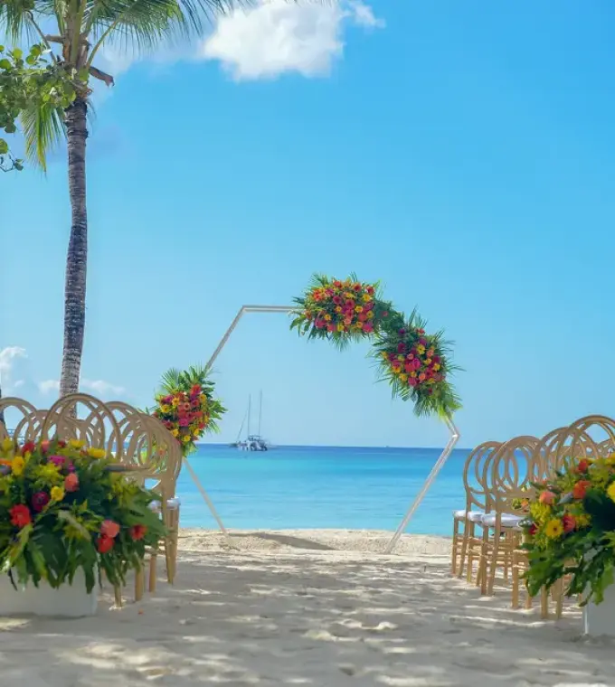 Beach wedding ceremony with a floral hexagonal arch at Secrets La Romana