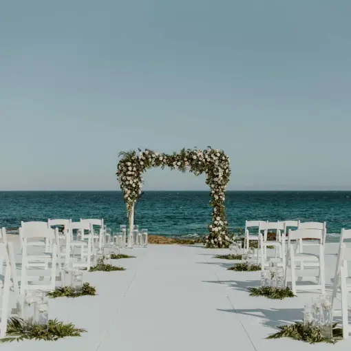 Beachfront wedding ceremony setup with floral arch at Hilton Los Cabos, Cabo San Lucas