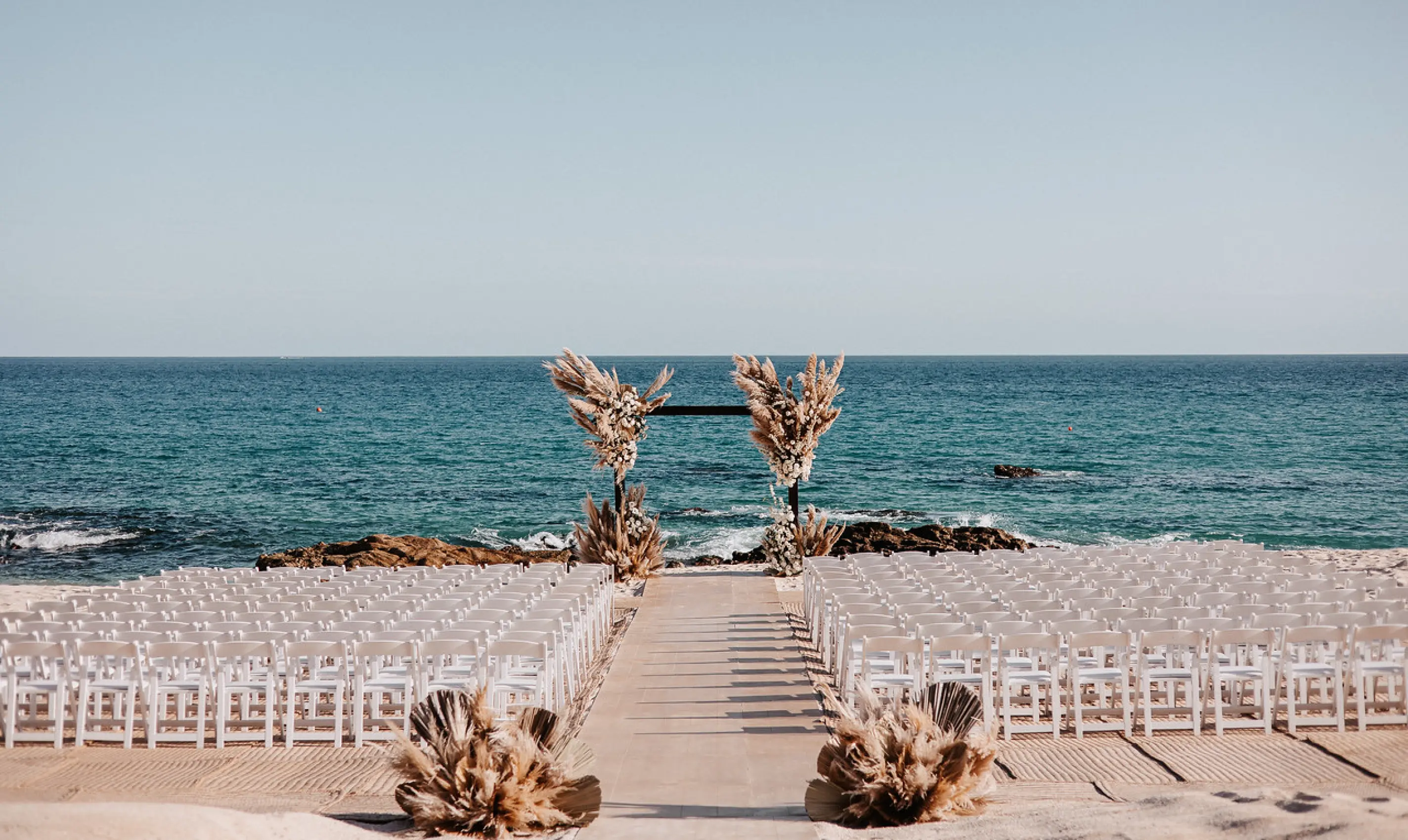 Beachfront wedding ceremony setup at Hilton Los Cabos, Cabo San Lucas