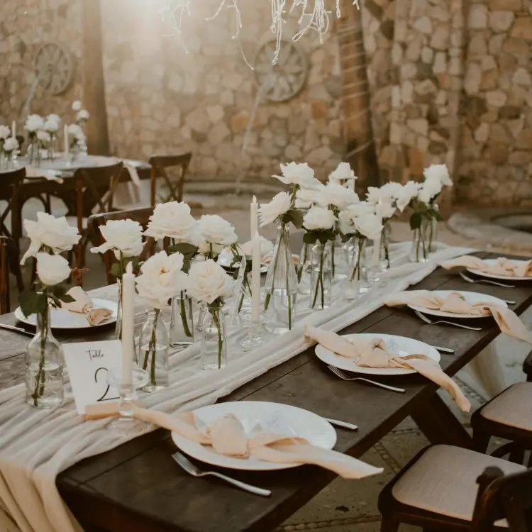 Outdoor wedding reception table with white roses and candles at Hilton Los Cabos, Cabo San Lucas