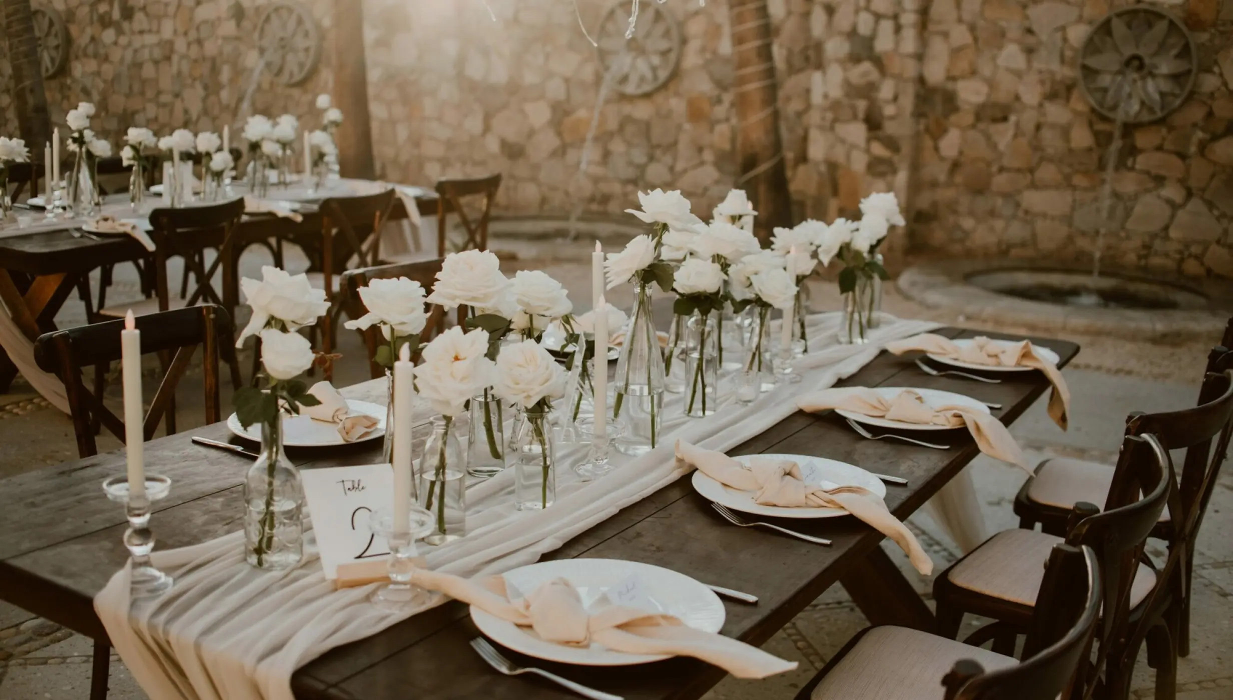 Outdoor wedding reception table with white roses and candles at Hilton Los Cabos, Cabo San Lucas