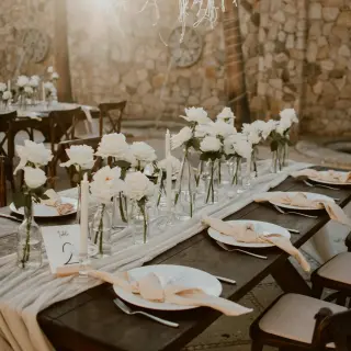 Outdoor wedding reception table with white roses and candles at Hilton Los Cabos, Cabo San Lucas