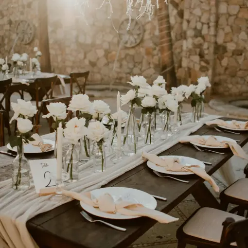 Outdoor wedding reception table with white roses and candles at Hilton Los Cabos, Cabo San Lucas