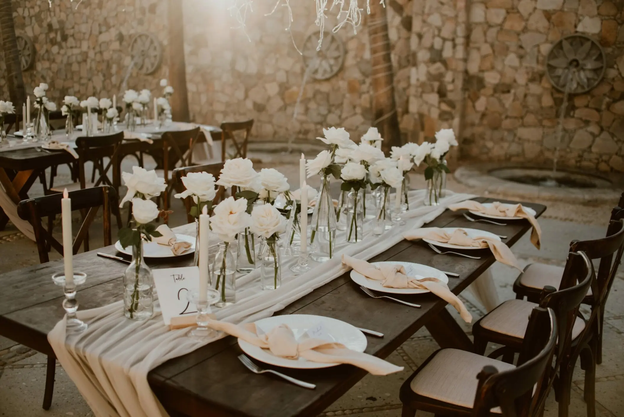 Outdoor wedding reception table with white roses and candles at Hilton Los Cabos, Cabo San Lucas