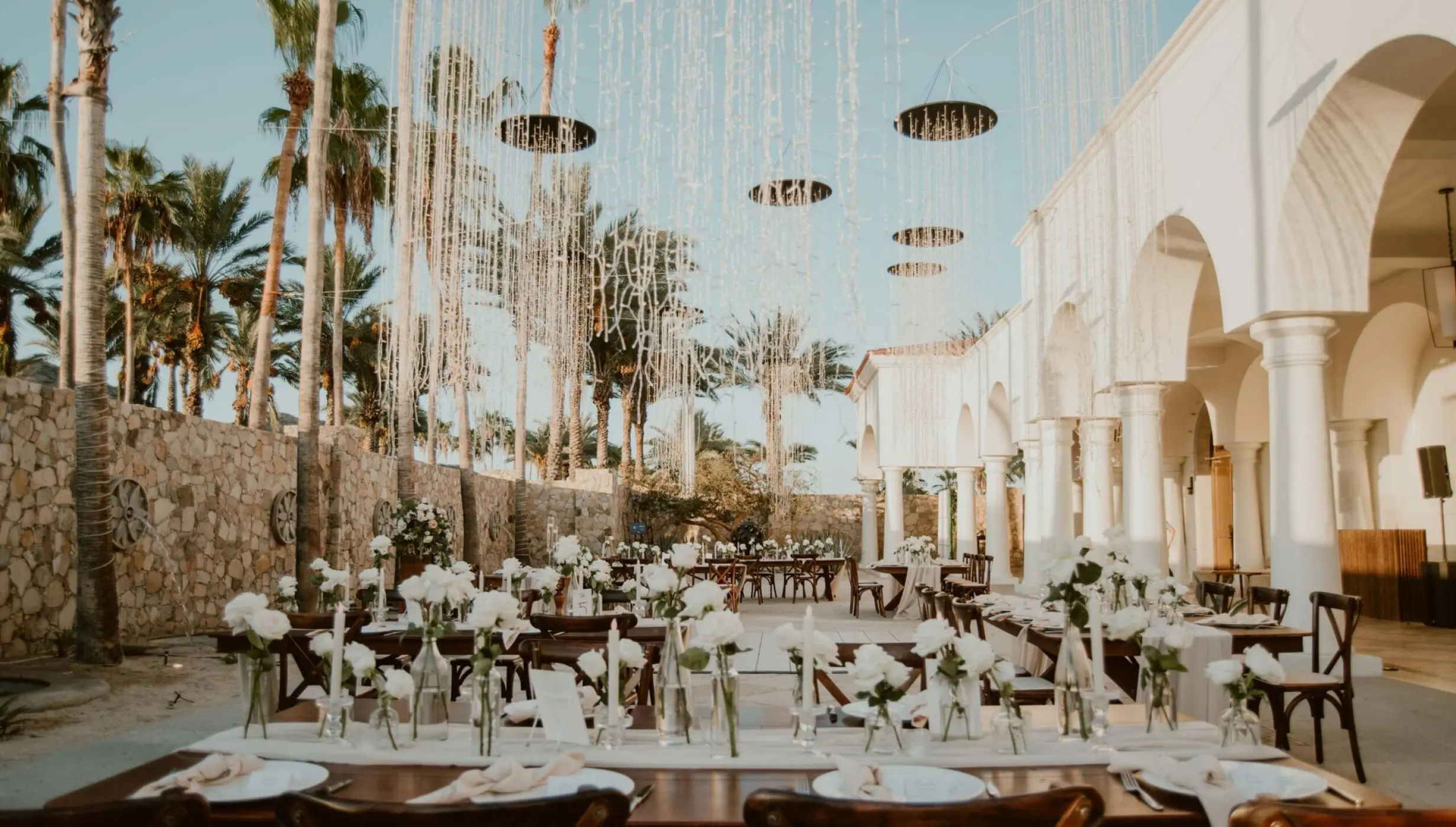 Outdoor wedding reception with white floral centerpieces on the El Dorado Terrace at Hilton Los Cabos, Cabo San Lucas