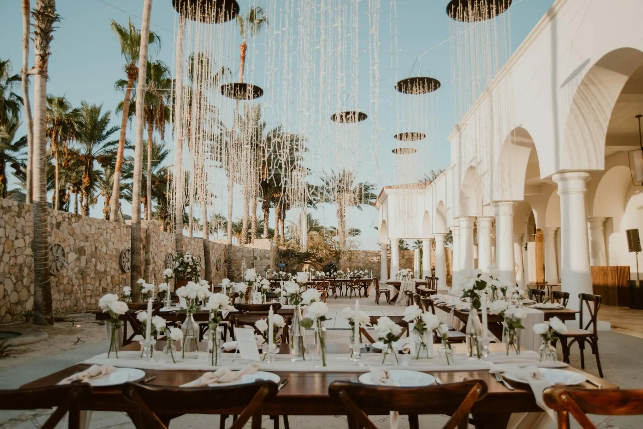 Outdoor wedding reception with white floral centerpieces on the El Dorado Terrace at Hilton Los Cabos, Cabo San Lucas