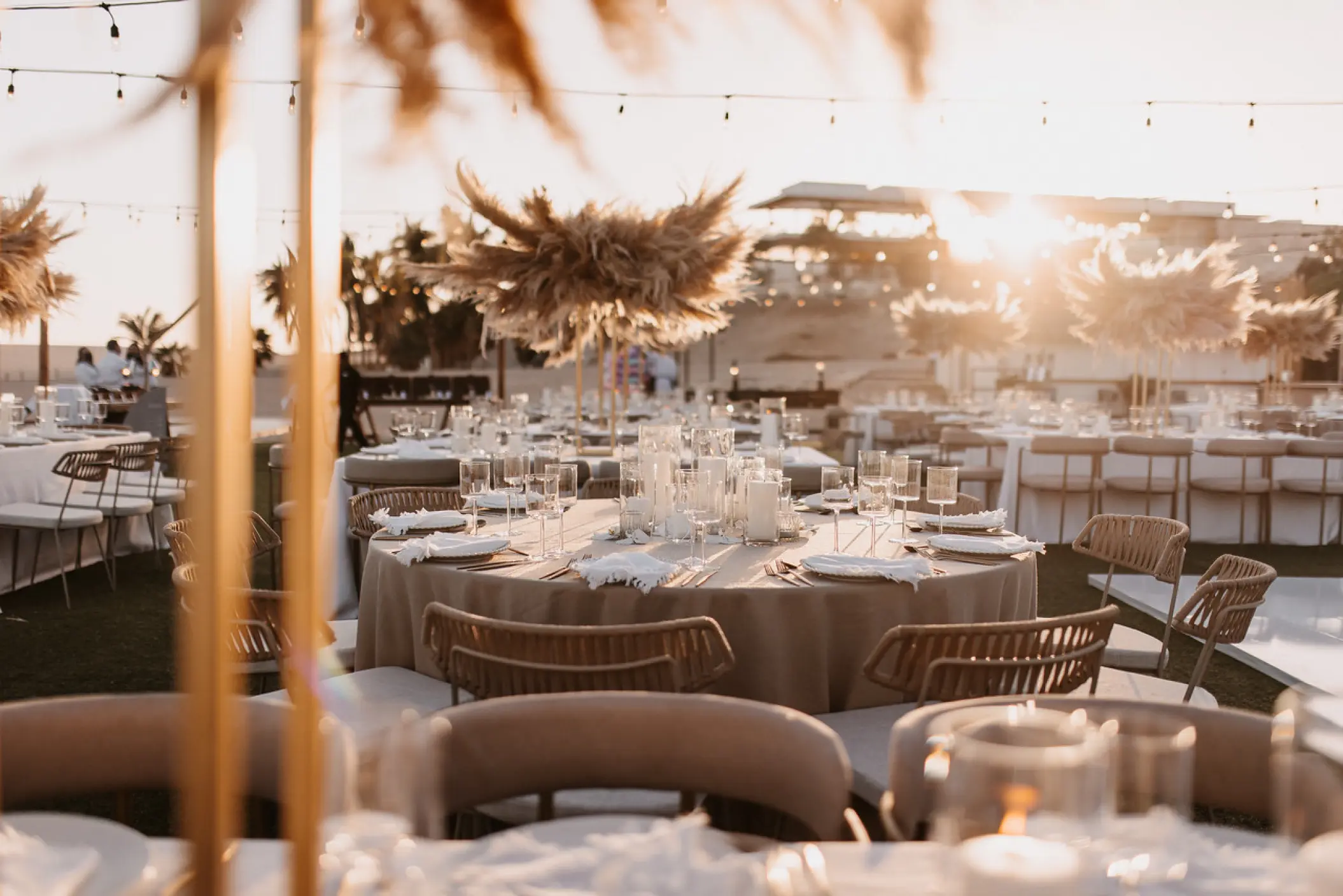 Outdoor wedding reception setup with pampas grass centerpieces at Hilton Los Cabos, Cabo San Lucas