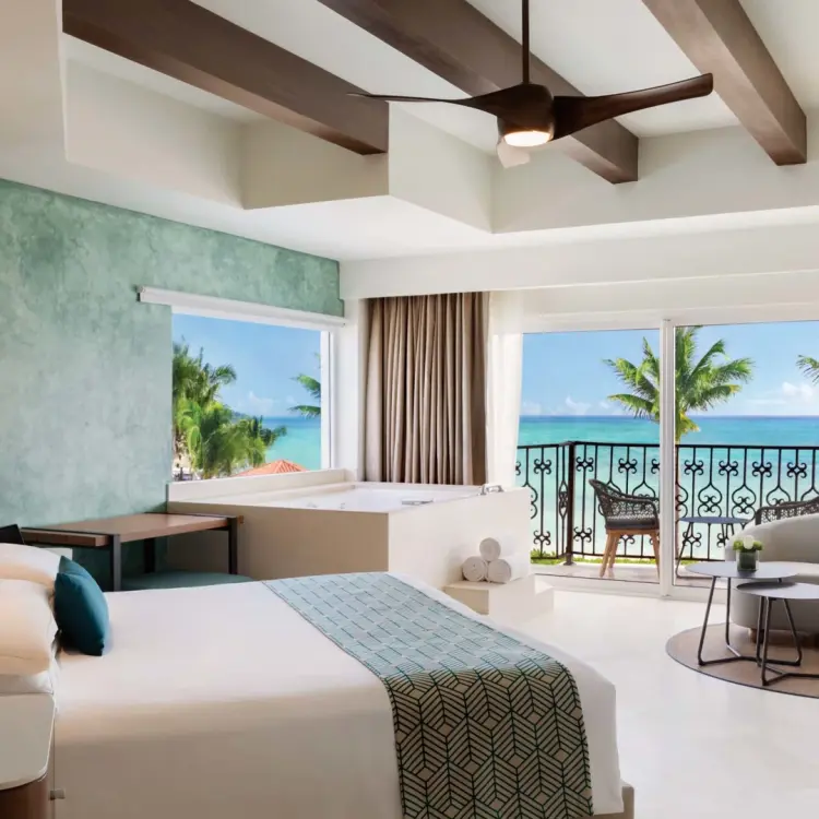 Oceanfront suite with a private balcony and seating area at Hyatt Vivid Playa del Carmen