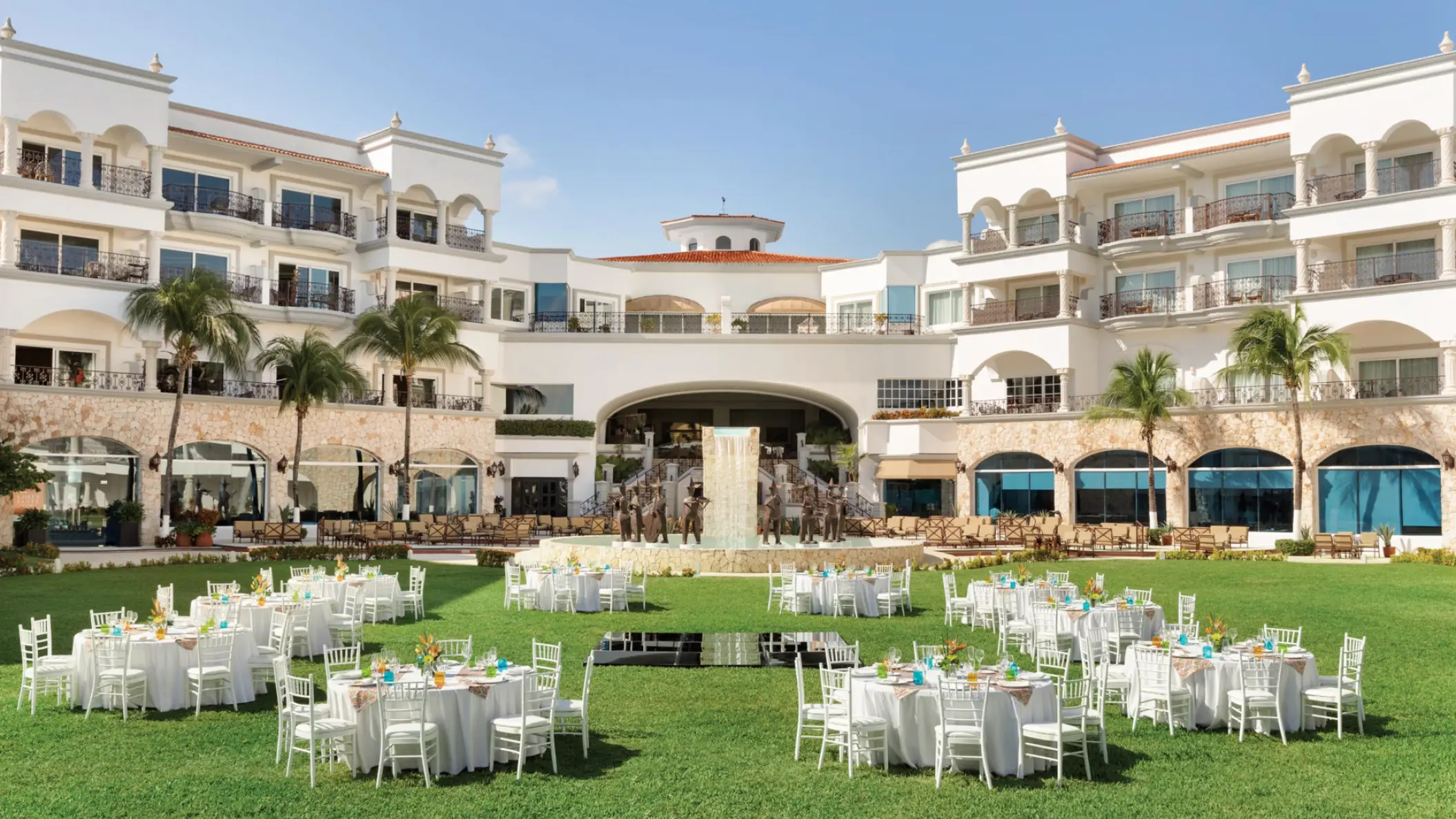 Garden wedding reception with white round tables at Hilton Playa del Carmen, Playa Del Carmen