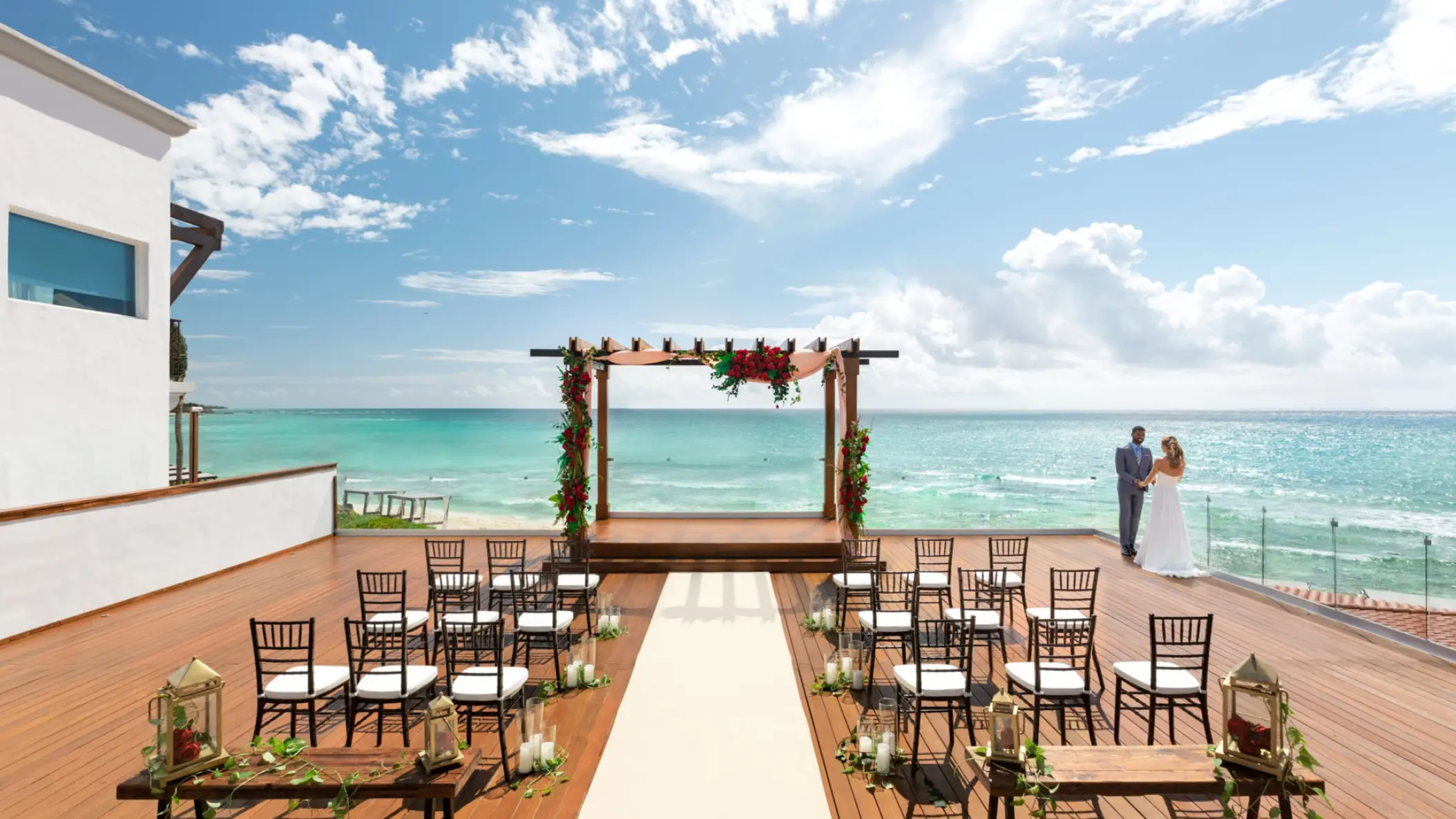 Oceanfront terrace wedding ceremony with floral pergola at Hilton Playa Del Carmen