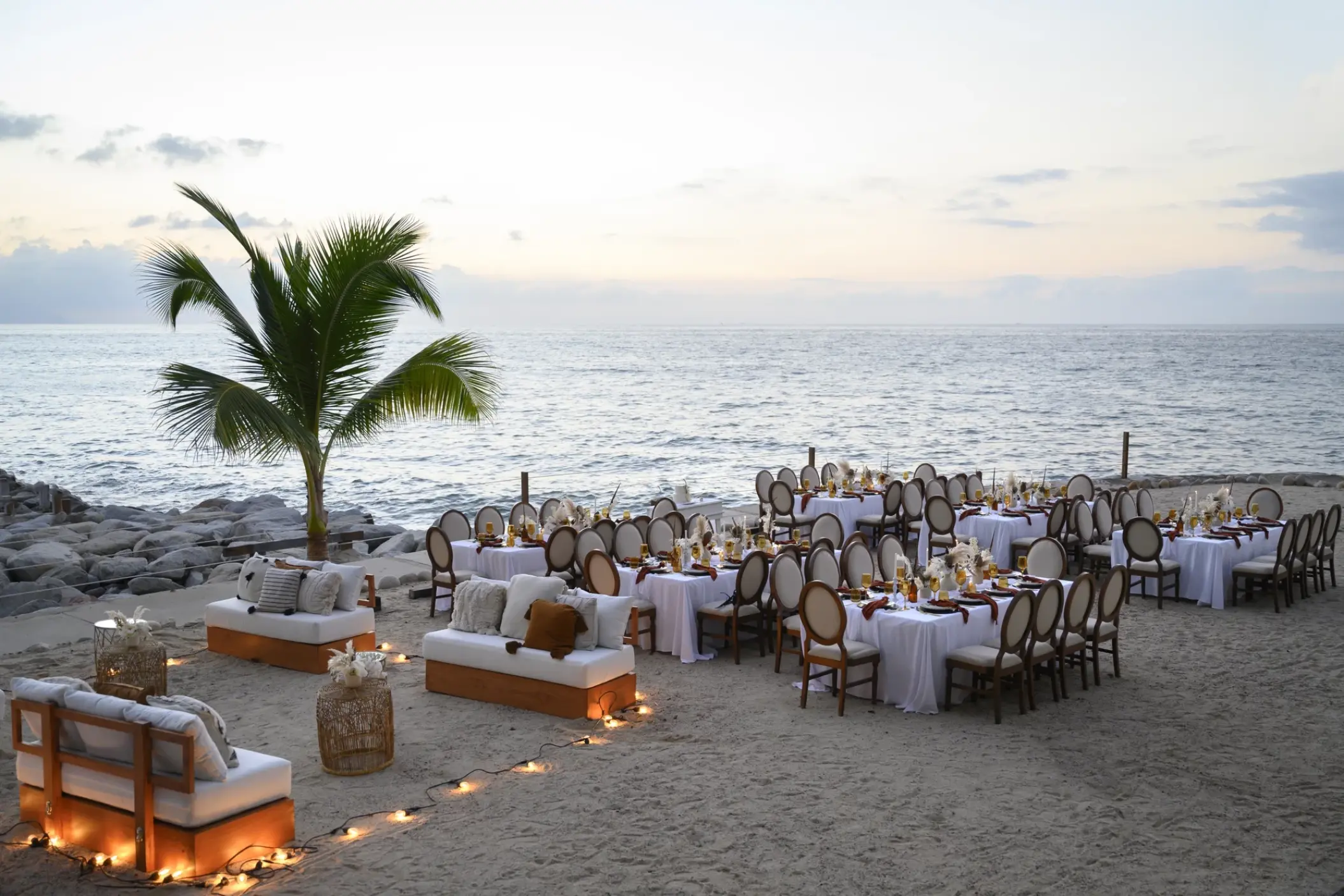Outdoor beach wedding reception with white linens and lounge seating at Hilton Vallarta Riviera, Puerto Vallarta