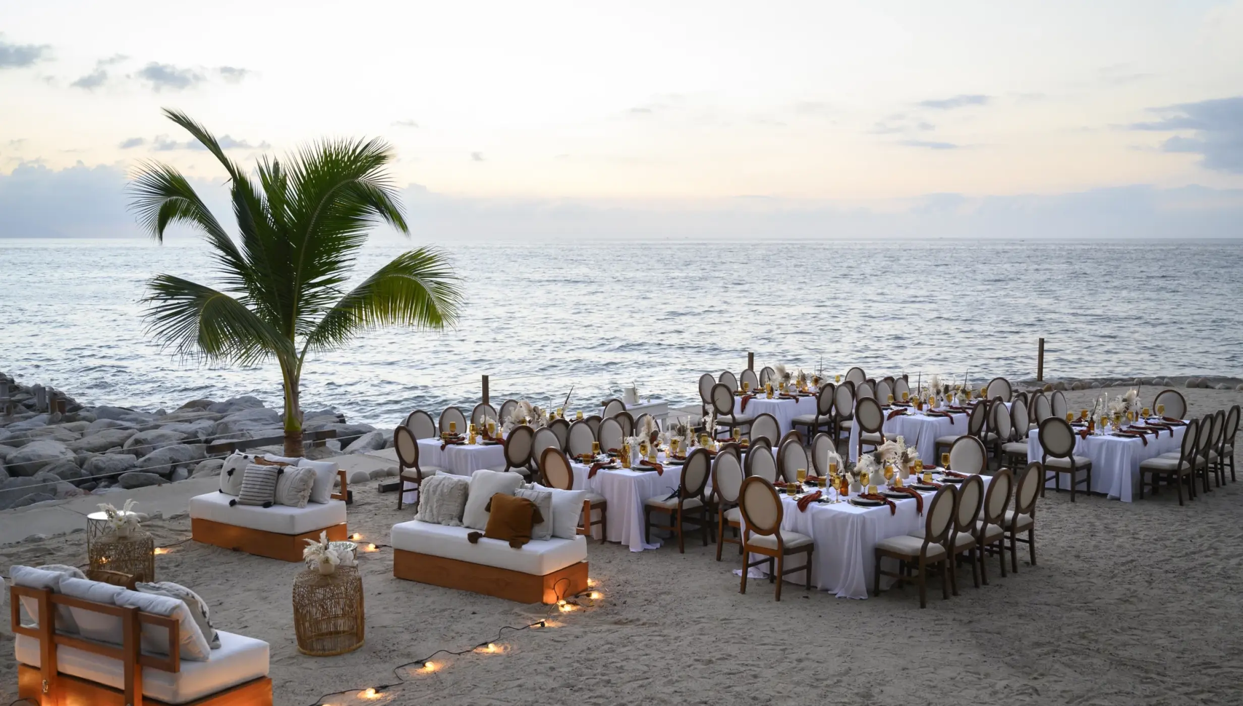 Outdoor beach wedding reception with white linens and lounge seating at Hilton Vallarta Riviera, Puerto Vallarta
