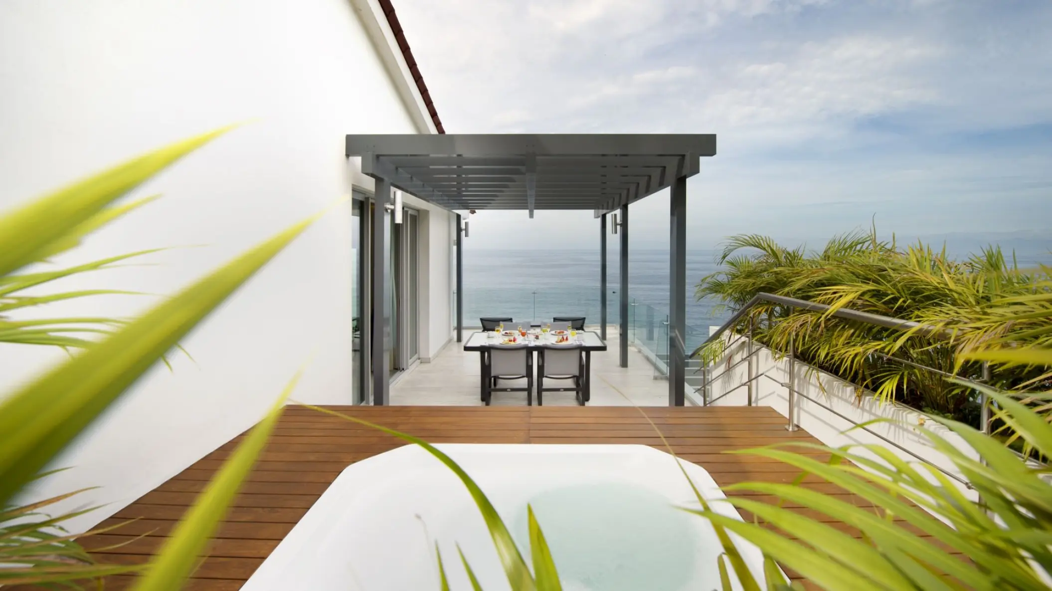 Private terrace with a whirlpool and dining table overlooking the ocean at Hilton Vallarta Riviera, Puerto Vallarta