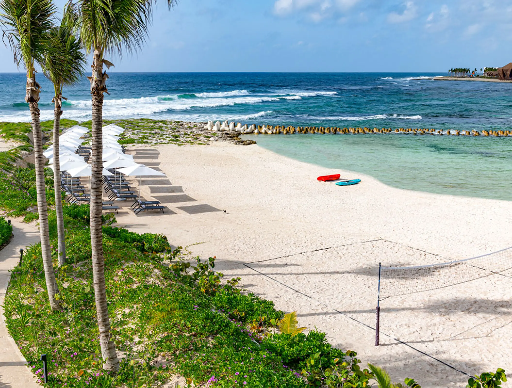 Hilton Tulum white sand beach with umbrellas and volleyball court, Tulum