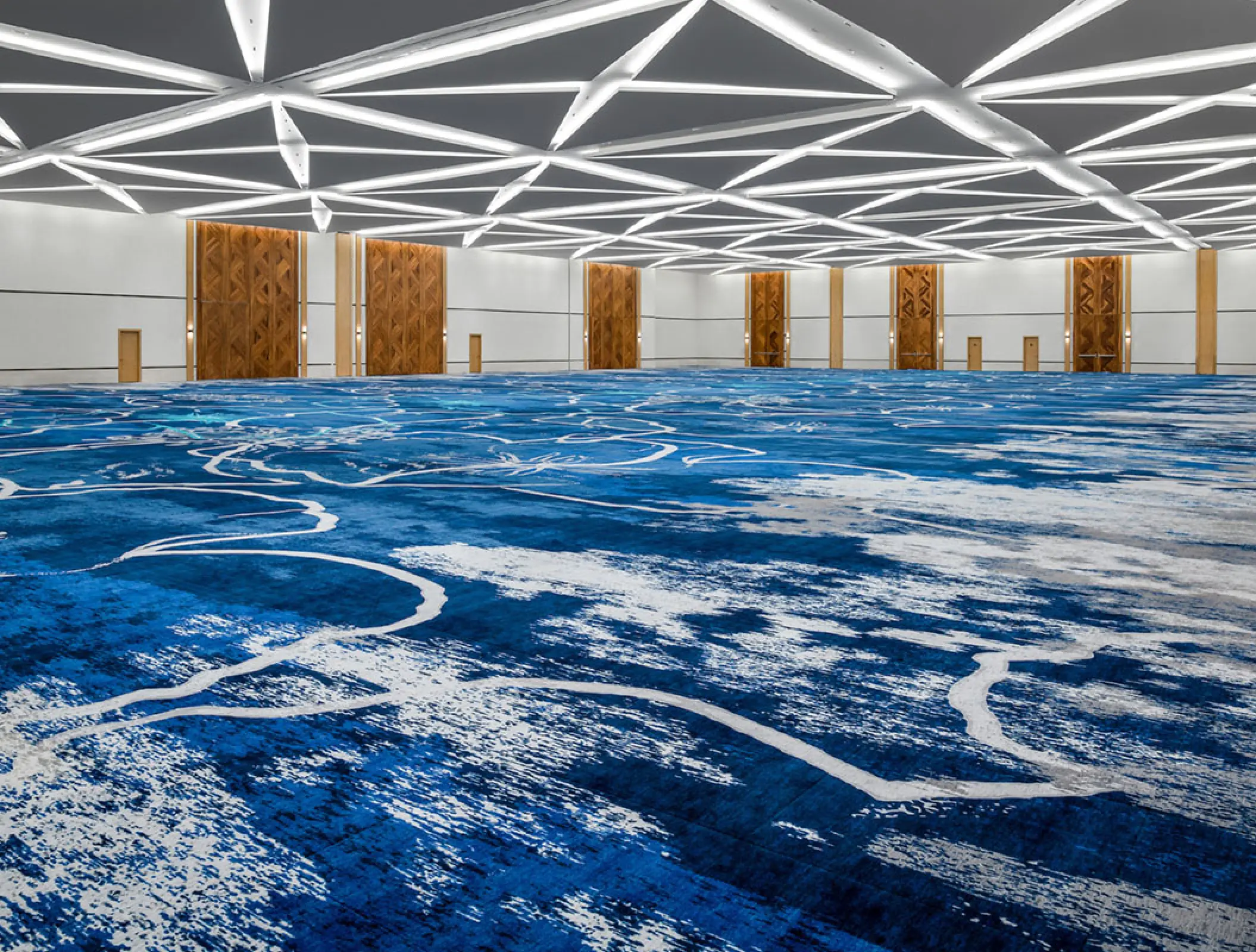 Tulkal Ballroom with blue patterned carpet and modern geometric ceiling at Hilton Tulum, Tulum