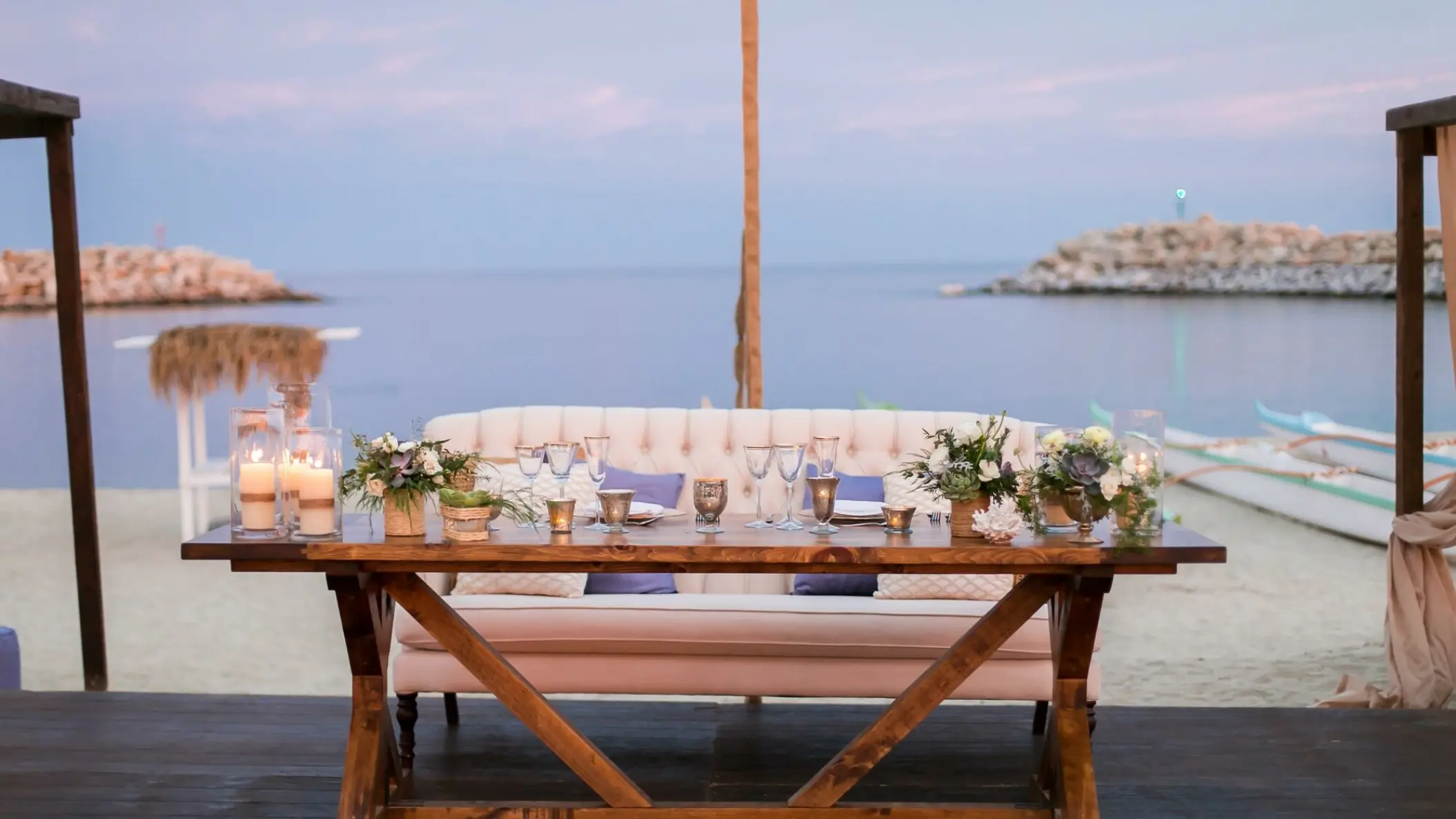 Sweetheart table with a white tufted sofa at a beachfront wedding reception, Hotel El Ganzo