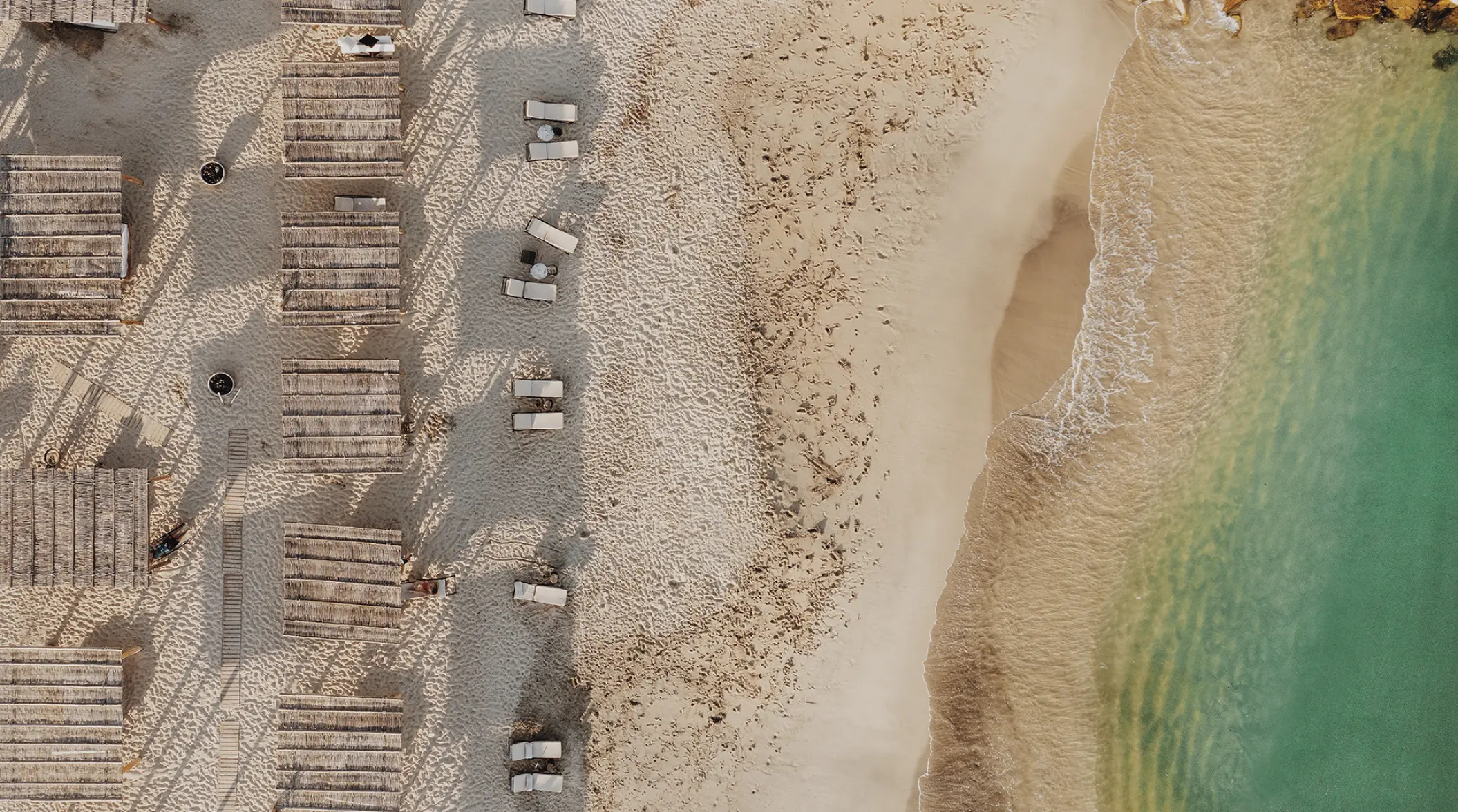 Aerial view of the beach and lounge chairs at Hotel El Ganzo, Cabo San Lucas