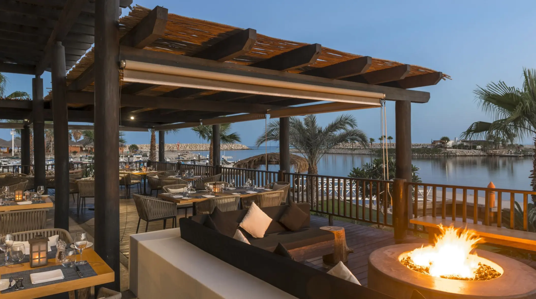 Outdoor restaurant and fire pit overlooking the marina at Hotel El Ganzo, Cabo San Lucas