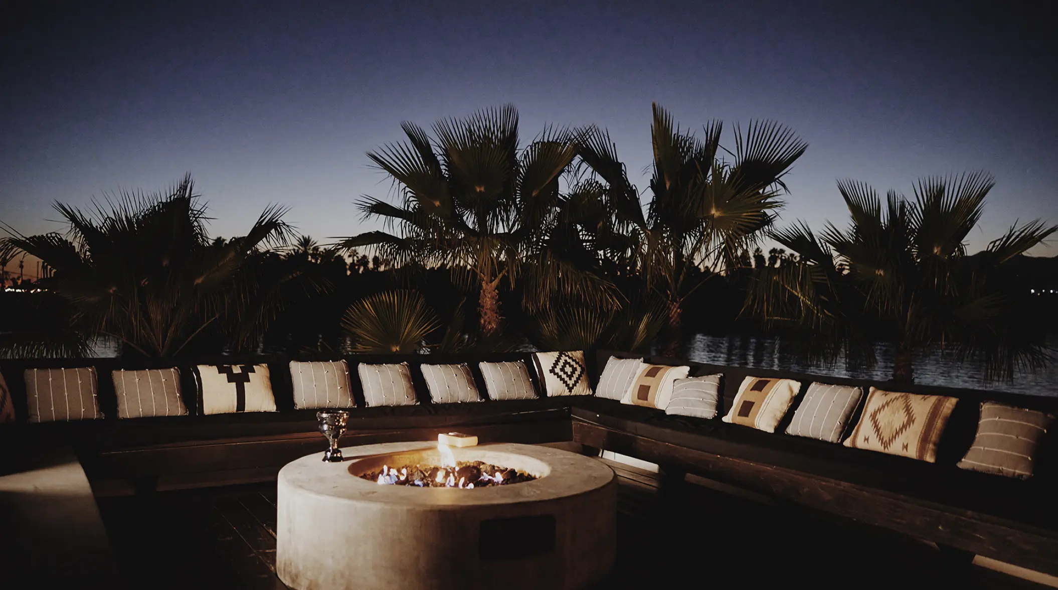 Outdoor lounge with fire pit and palm trees at night, Hotel El Ganzo, Cabo San Lucas
