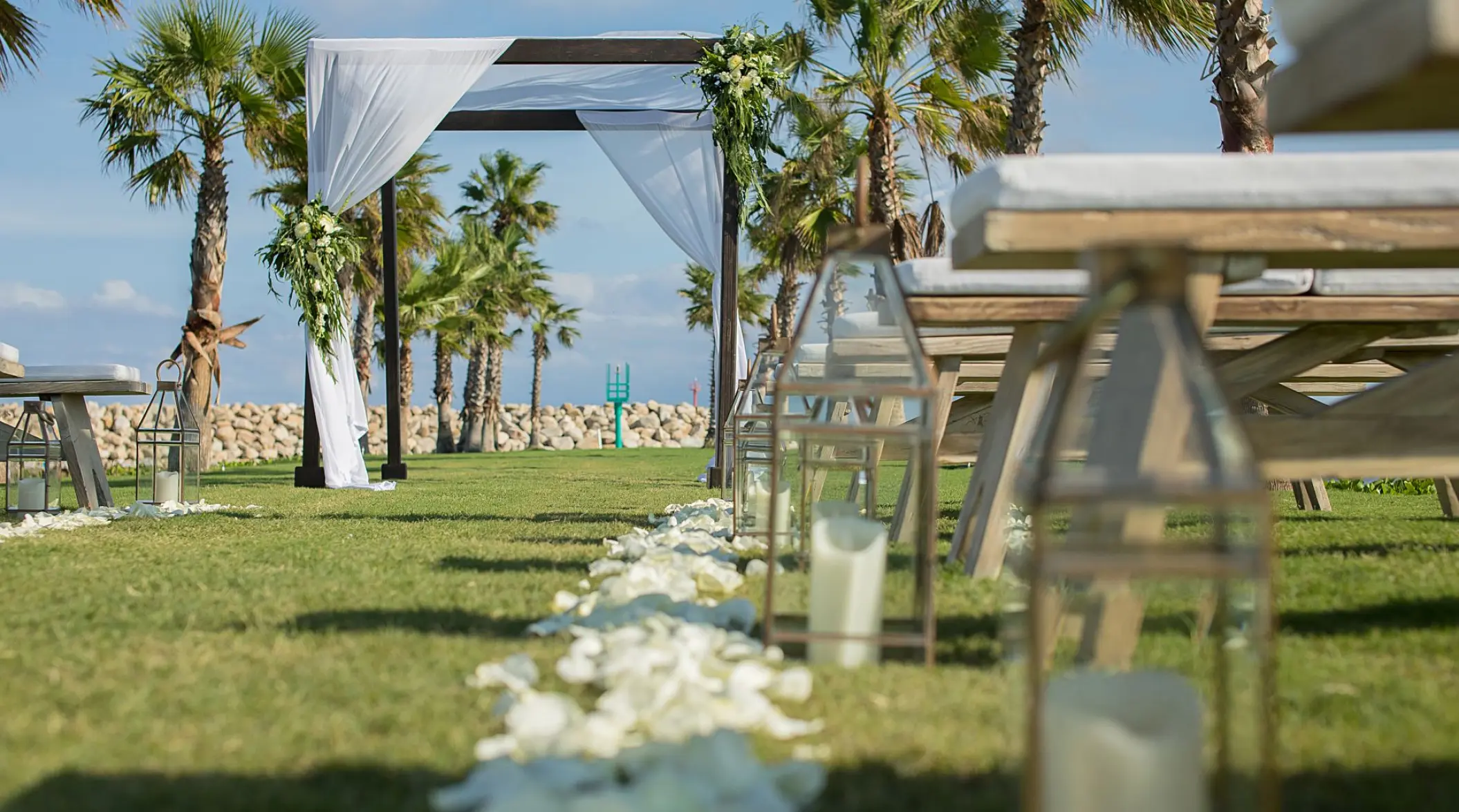 Outdoor wedding ceremony setup with flower petals and lanterns on the lawn at Hotel El Ganzo, Cabo San Lucas