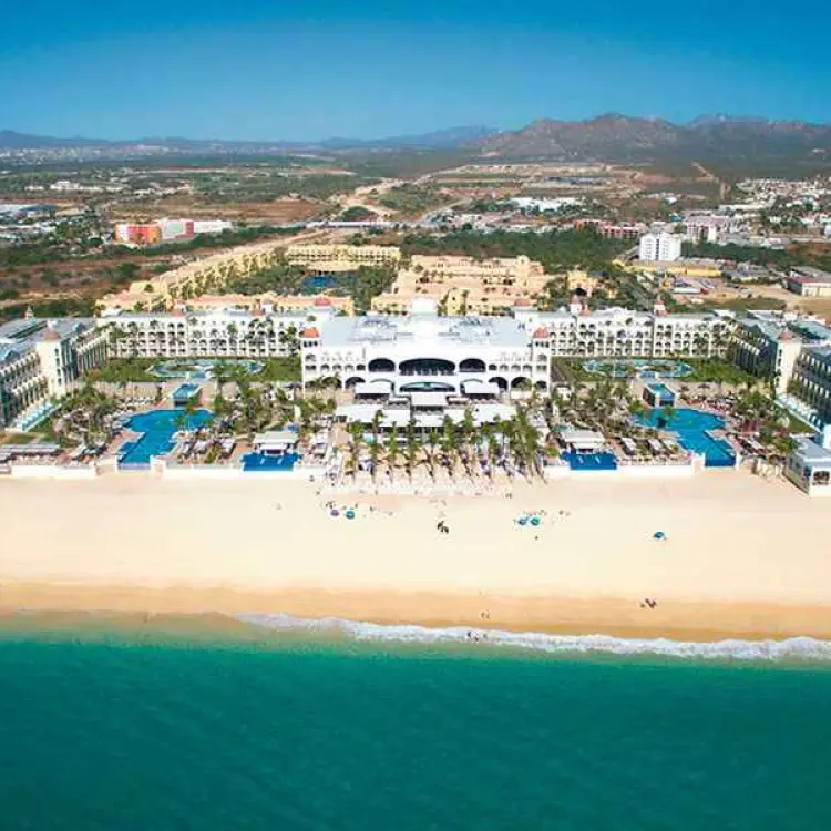 Aerial view of Riu Palace Cabo San Lucas beachfront buildings and pools by the sea