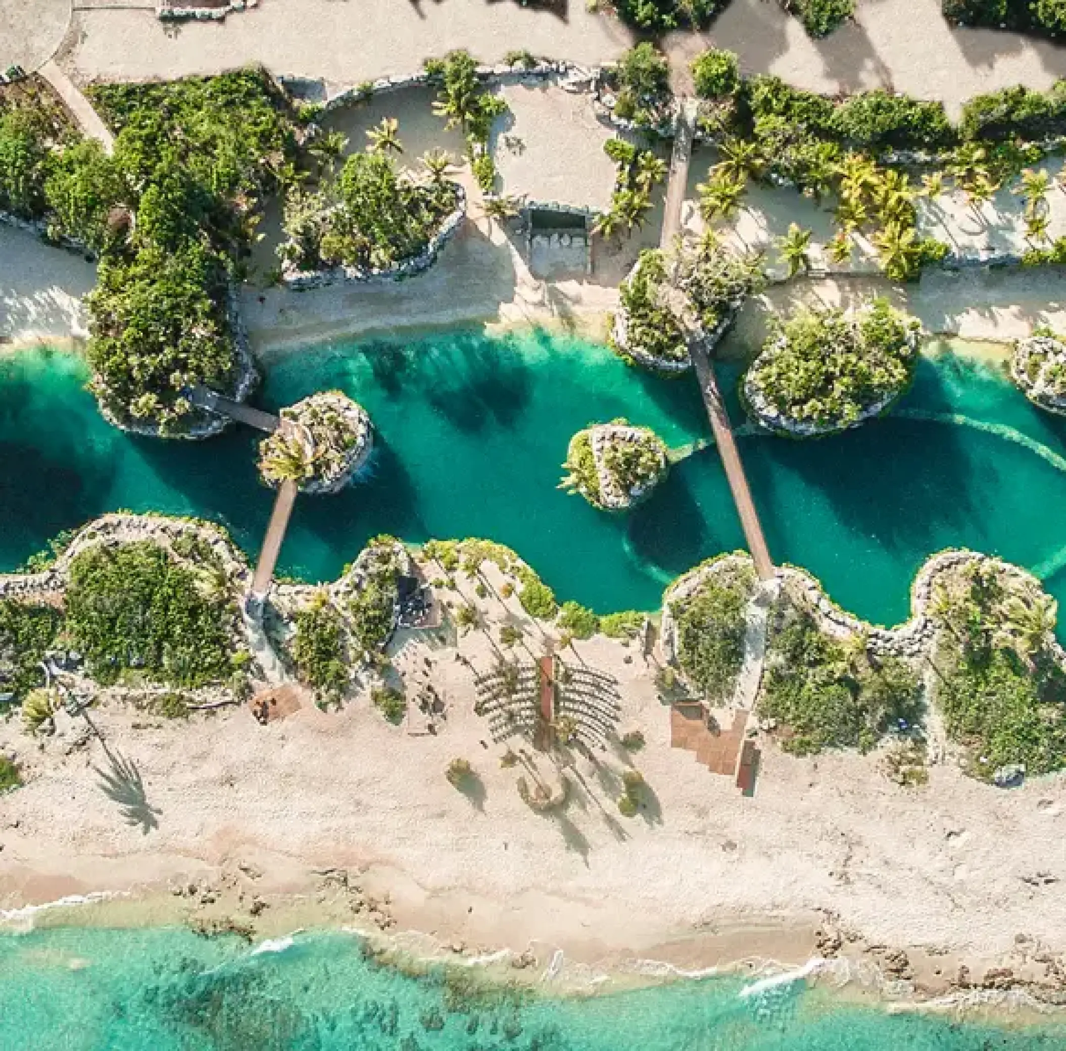 Aerial view of turquoise lagoons and bridges at Hotel Xcaret Arte, Riviera Maya
