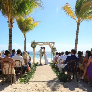 Beachfront wedding ceremony between palm trees at Hotel Xcaret Arte, Riviera Maya