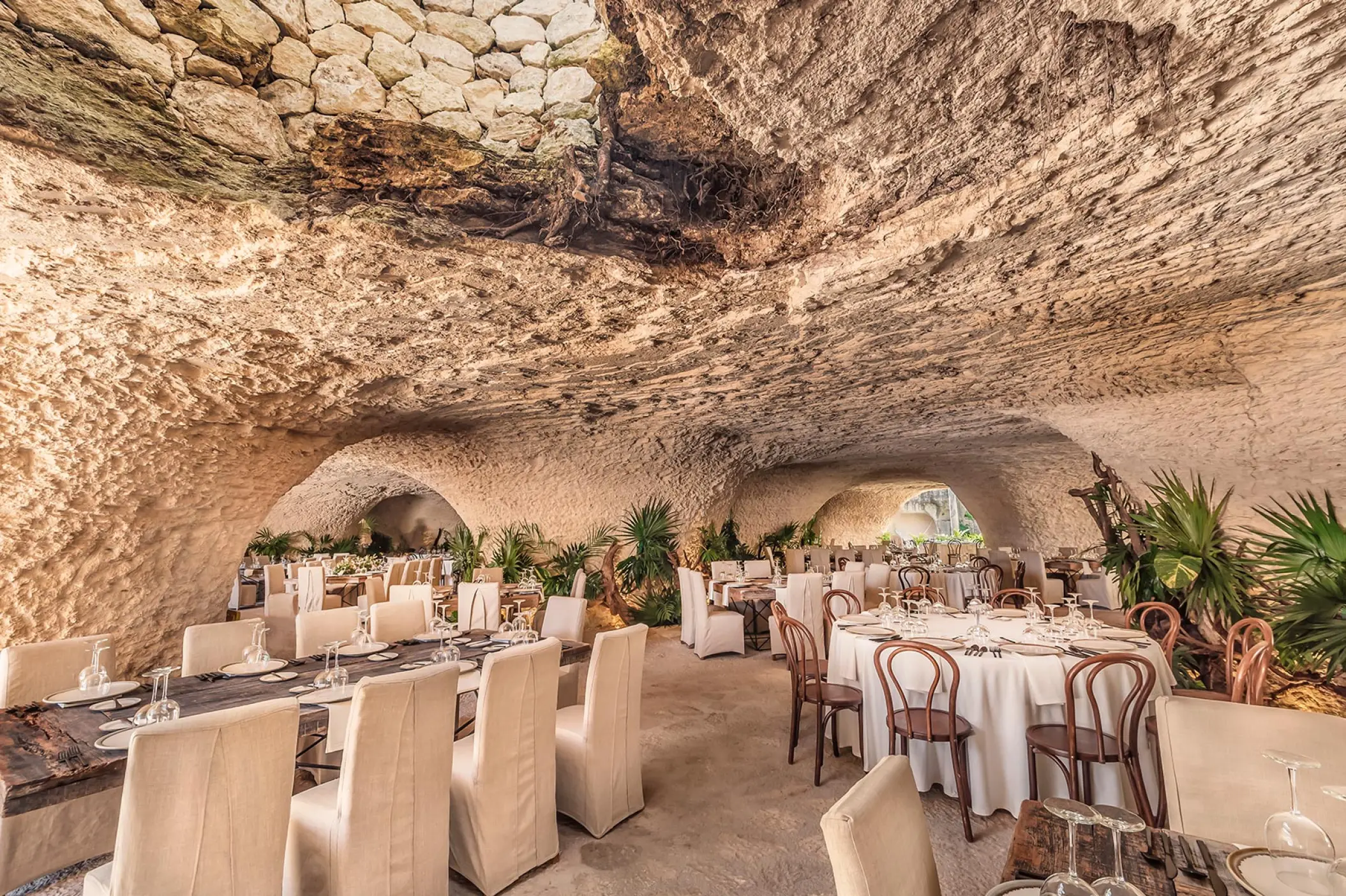 Cave wedding reception venue with round and long tables at Hotel Xcaret Arte, Riviera Maya