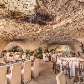 Cave wedding reception venue with round and long tables at Hotel Xcaret Arte, Riviera Maya