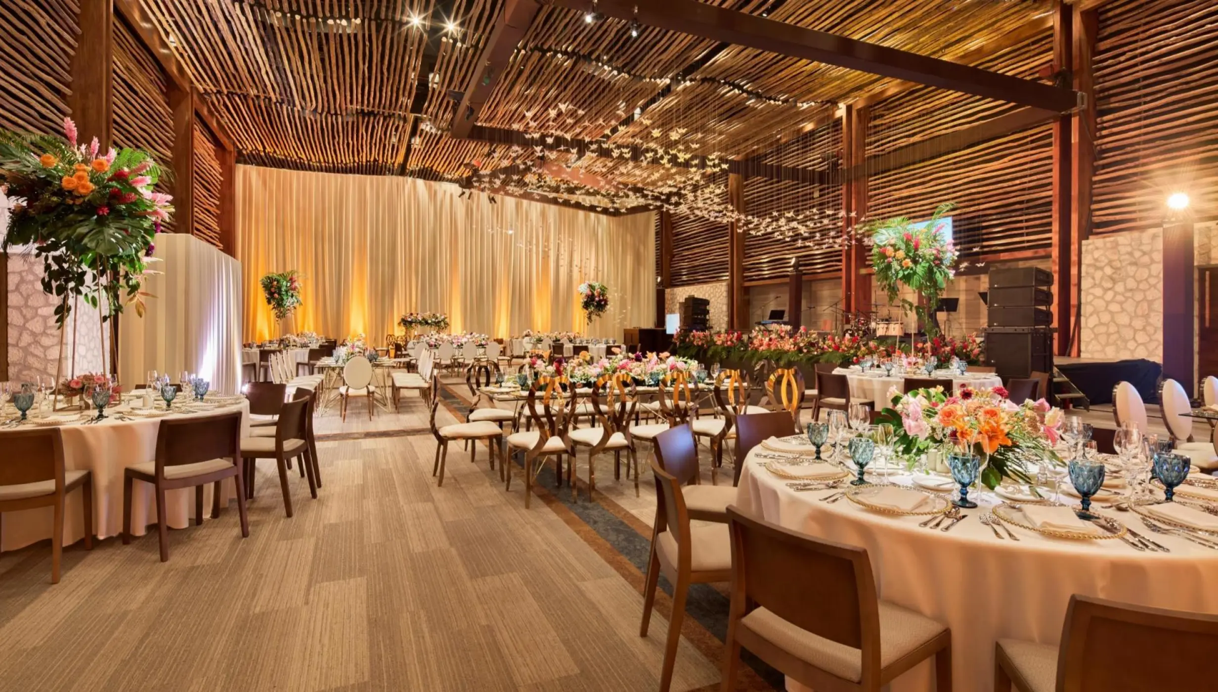 Frida Ballroom wedding reception with wooden accents and floral centerpieces at Hotel Xcaret Arte, Riviera Maya