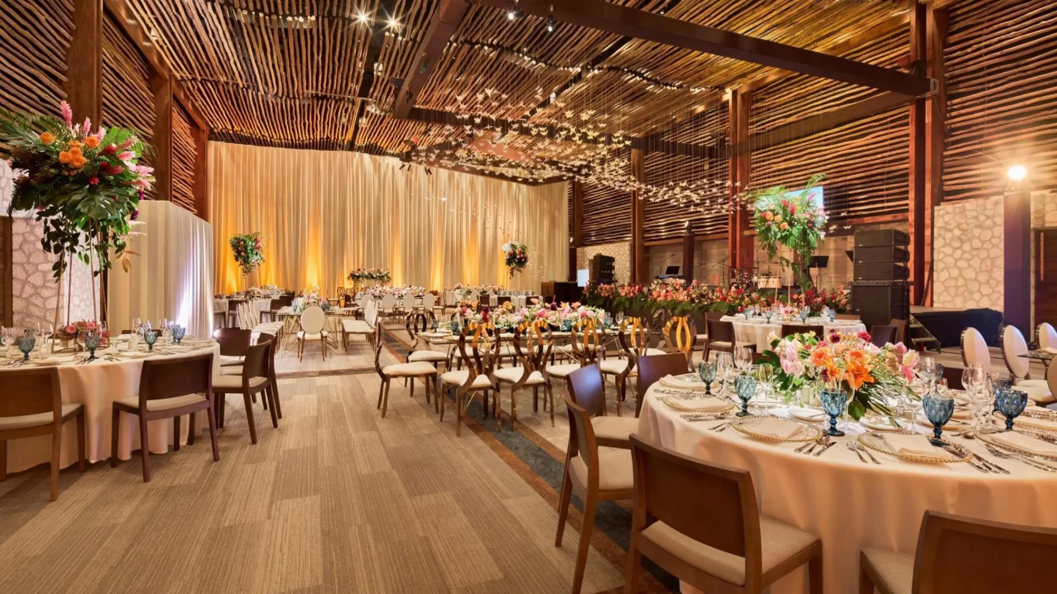 Frida Ballroom wedding reception with wooden accents and floral centerpieces at Hotel Xcaret Arte, Riviera Maya
