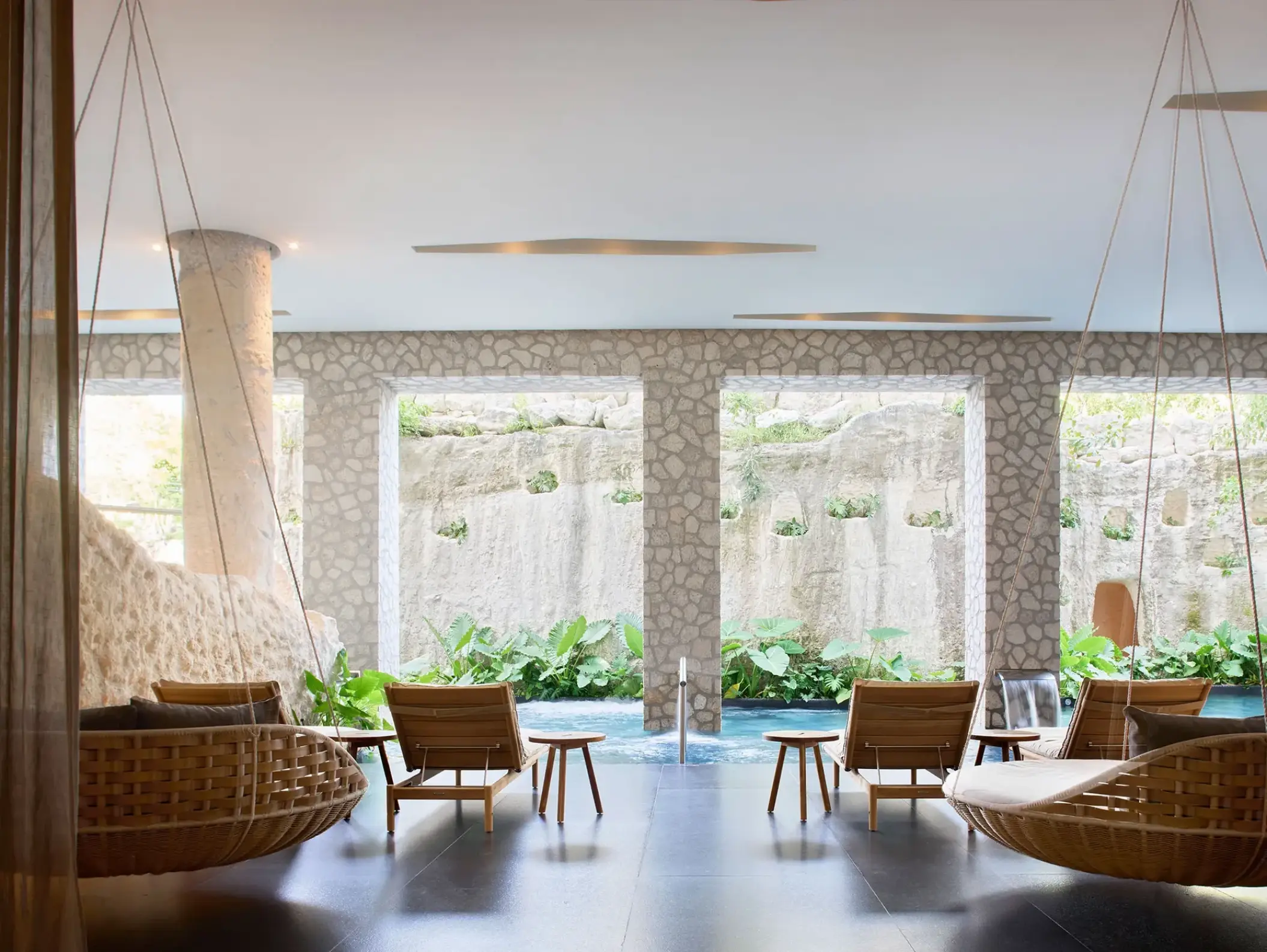 Woven hanging chairs and loungers in the indoor spa at Hotel Xcaret Arte, Riviera Maya