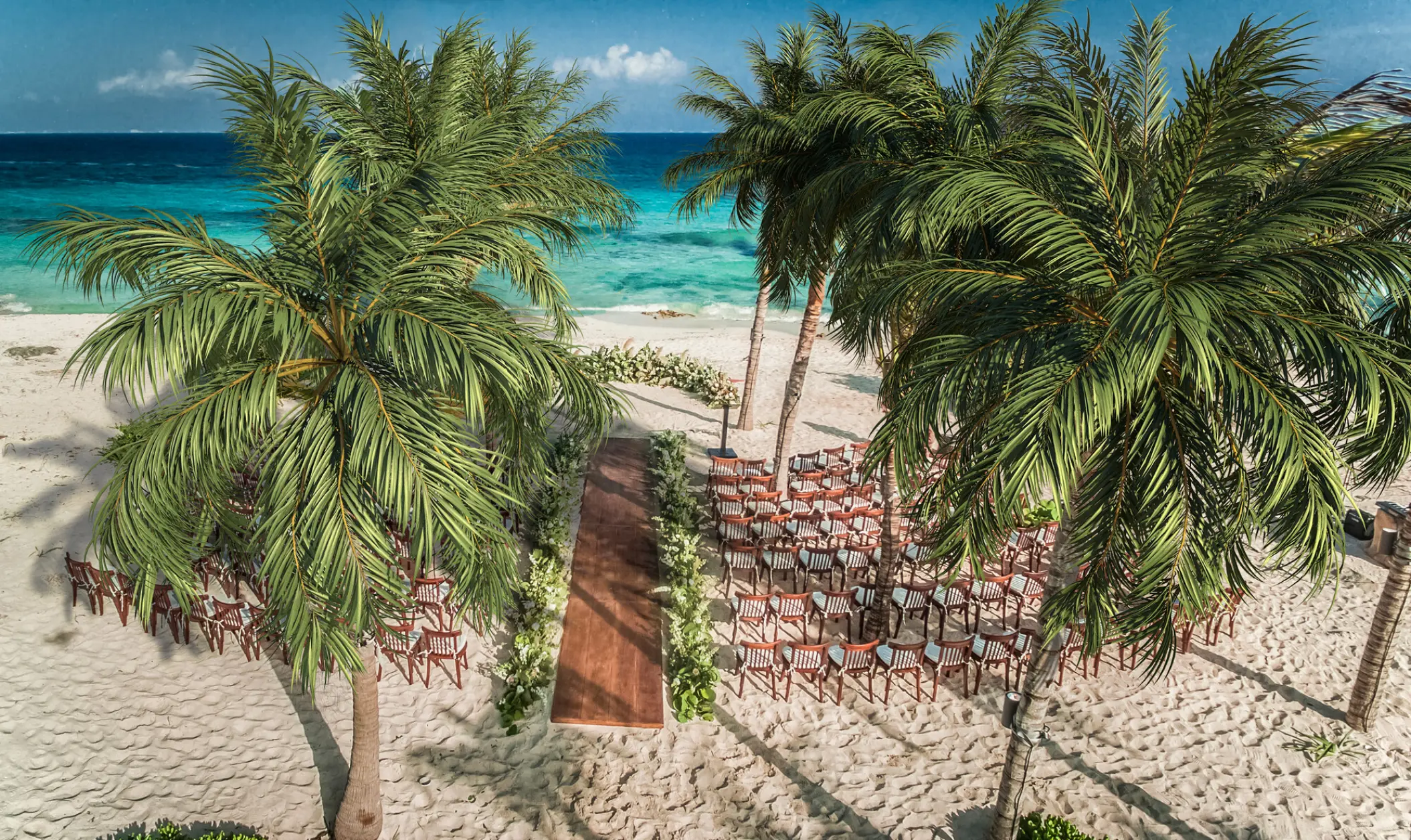 Beachfront wedding ceremony setup with palm trees at Hotel Xcaret Mexico, Riviera Maya