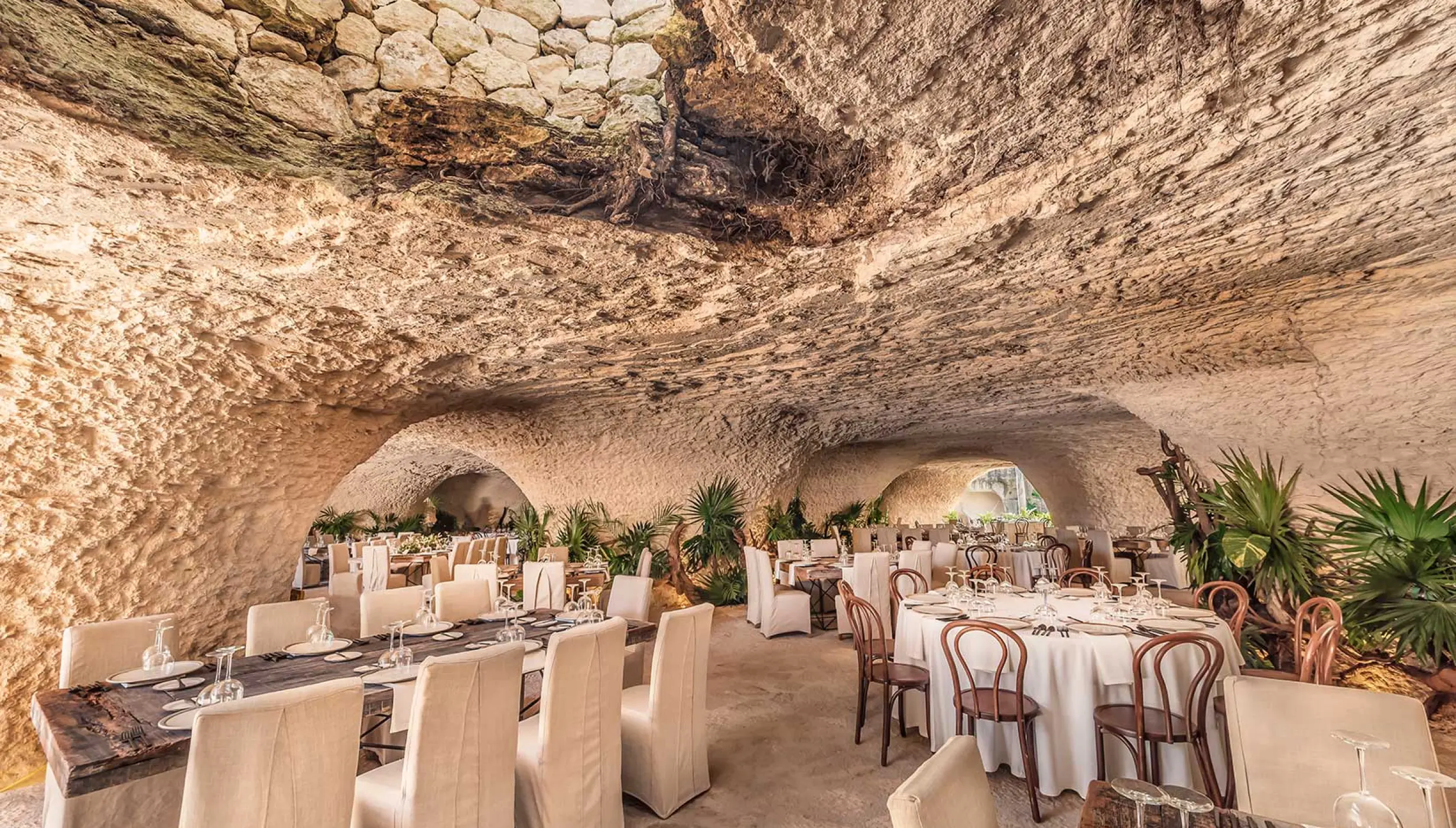wedding venue reception in caves with tables and chairs at Hotel Xcaret Mexico