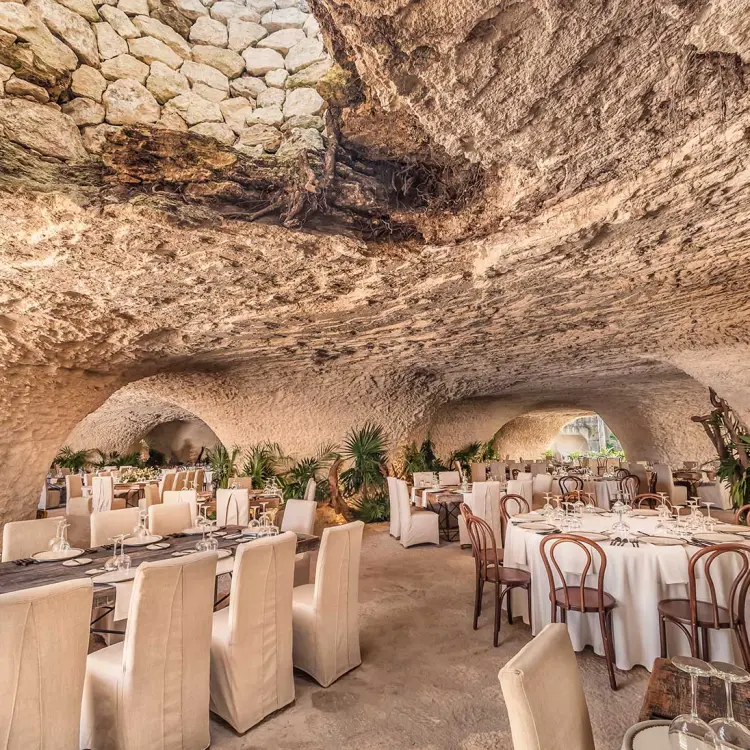 Cave wedding reception venue with set tables and tropical plants at Hotel Xcaret Mexico, Riviera Maya
