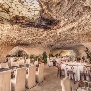 Cave wedding reception venue with set tables and tropical plants at Hotel Xcaret Mexico, Riviera Maya