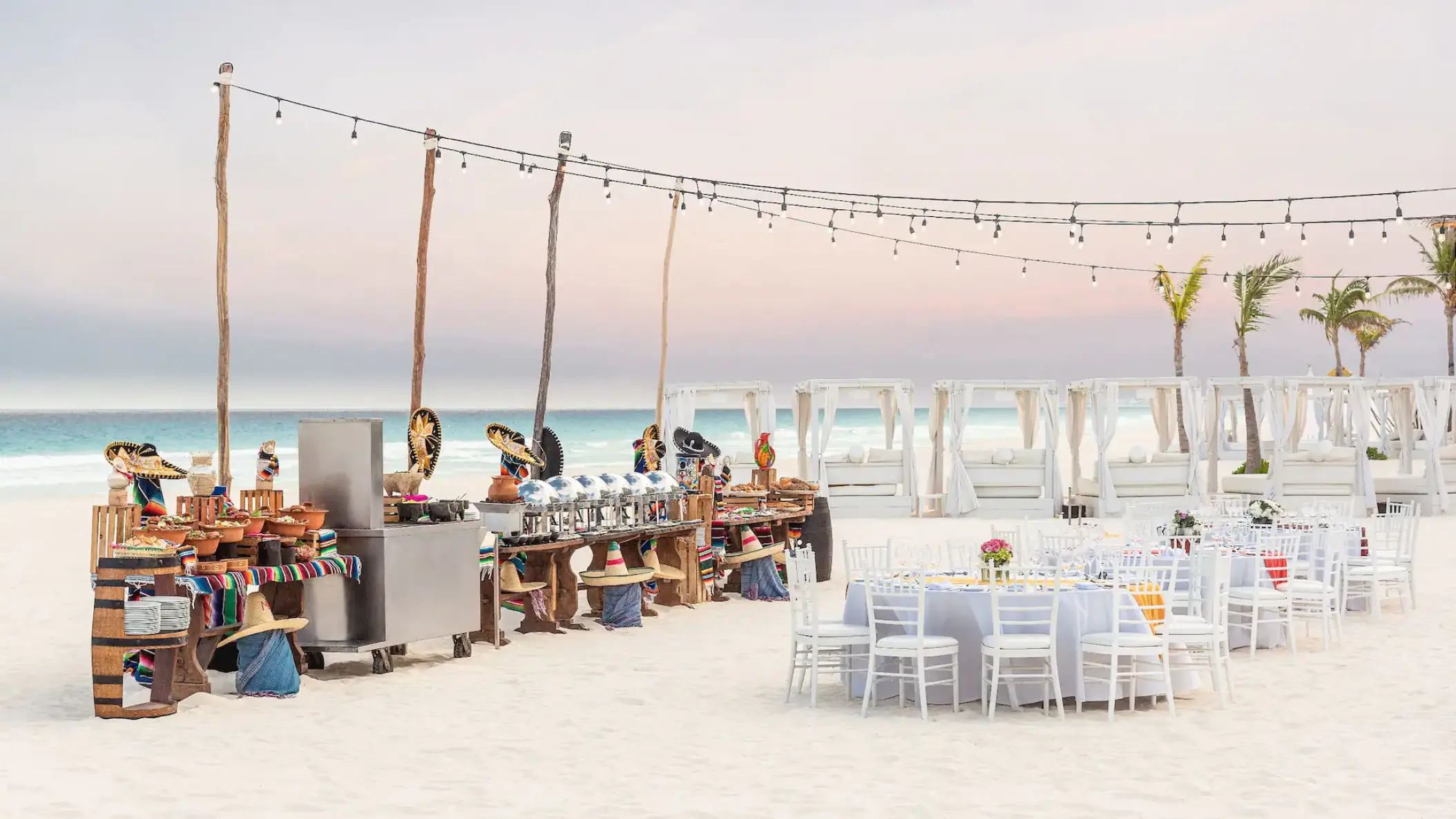 Beachfront wedding reception setup with string lights and buffet at Hyatt Zilara Cancun