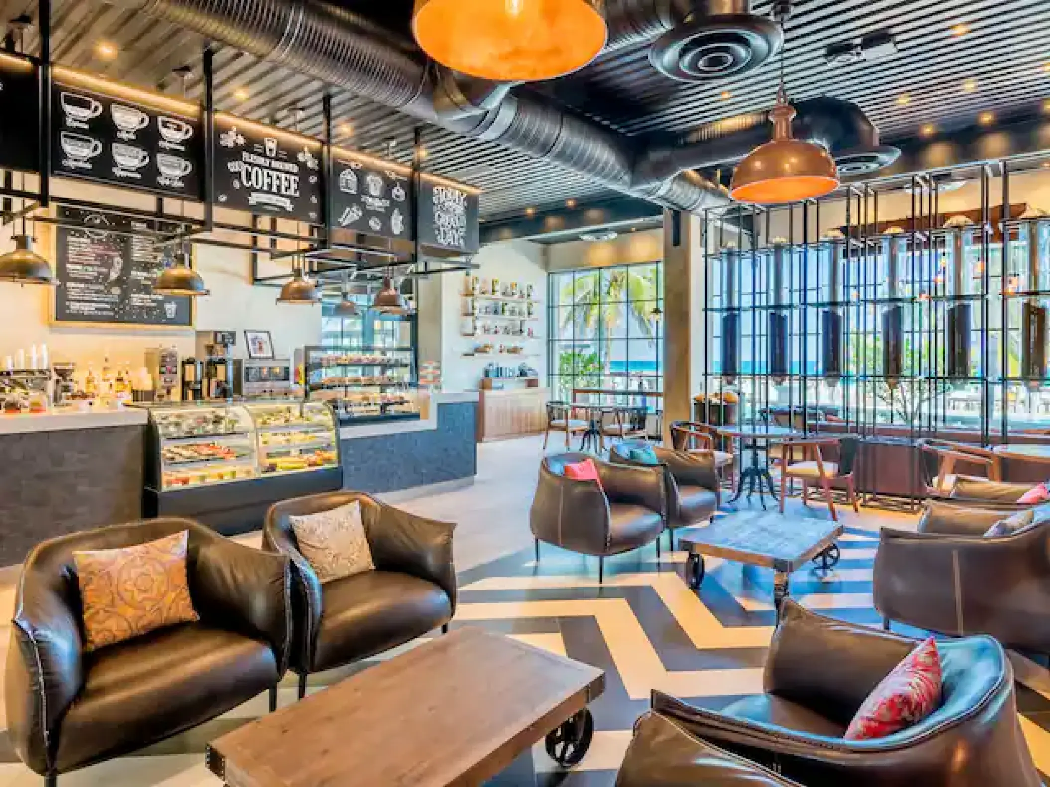 Casa de Cafe lounge with industrial décor and leather armchairs at Hyatt Zilara Cancun
