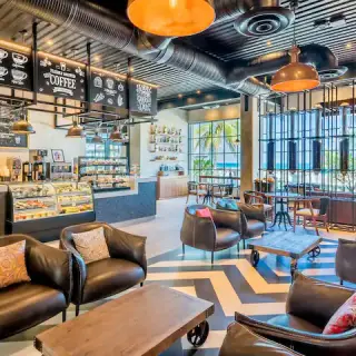 Casa de Cafe lounge with industrial décor and leather armchairs at Hyatt Zilara Cancun