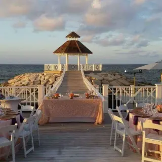 Outdoor wedding reception setup on a pier with an oceanfront gazebo at Hyatt Zilara Rose Hall, Montego Bay